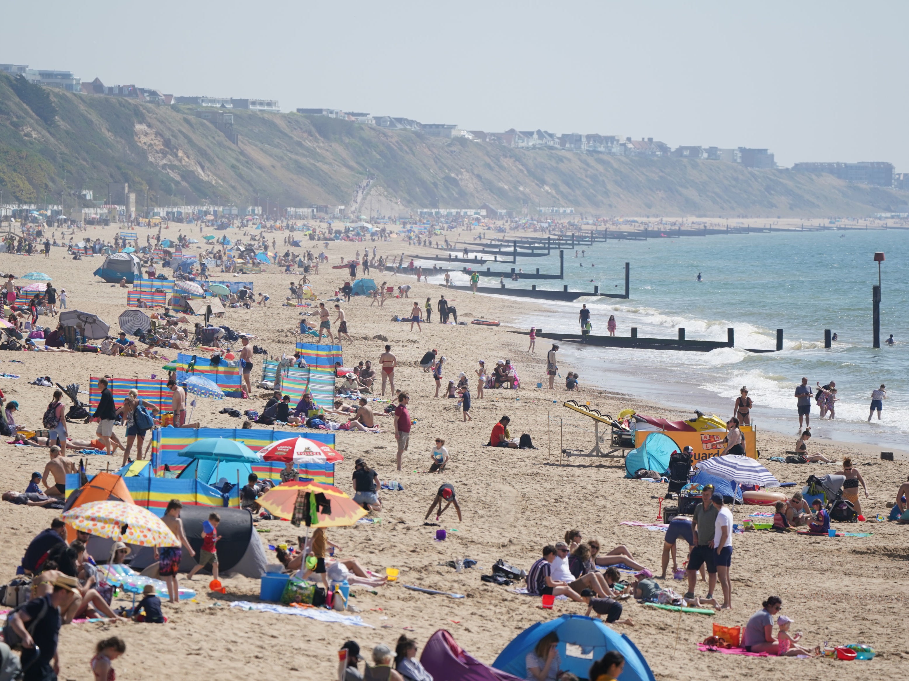 People gather in the good weather at Boscombe beach, Dorset