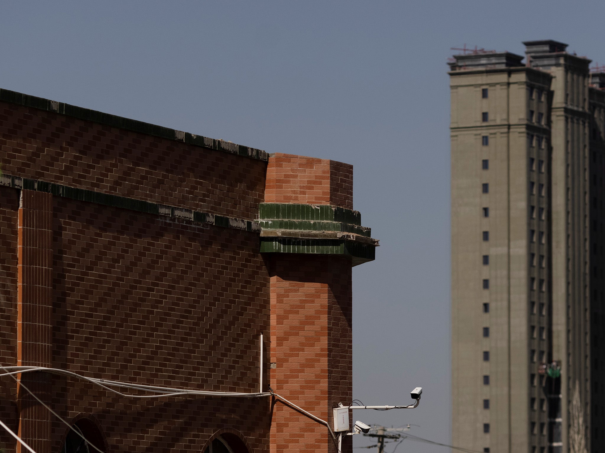 Apartment towers in Changji rise behind a former mosque, which had its minarets removed. Around 16,000 mosques have been destroyed since 2017