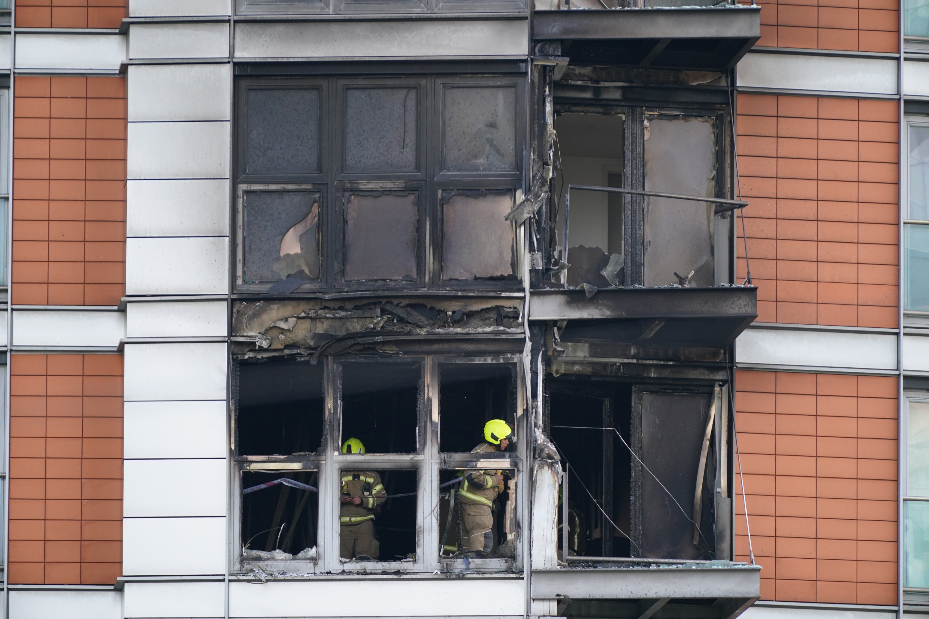 Firefighters inspect damage to a 19-storey tower block in New Providence Wharf in London, May 2021