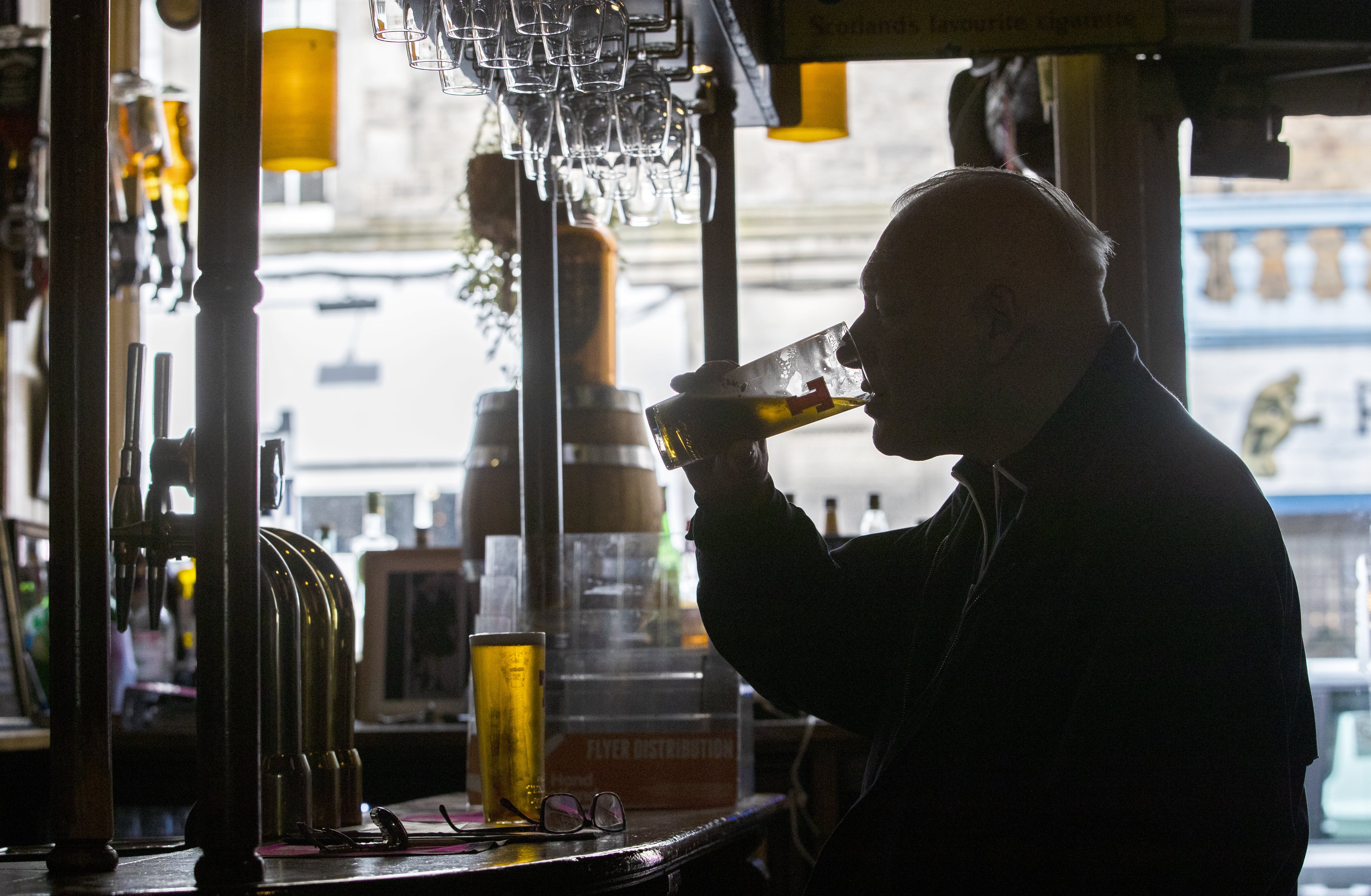 A man drinking in a public house (Jane Barlow/PA)