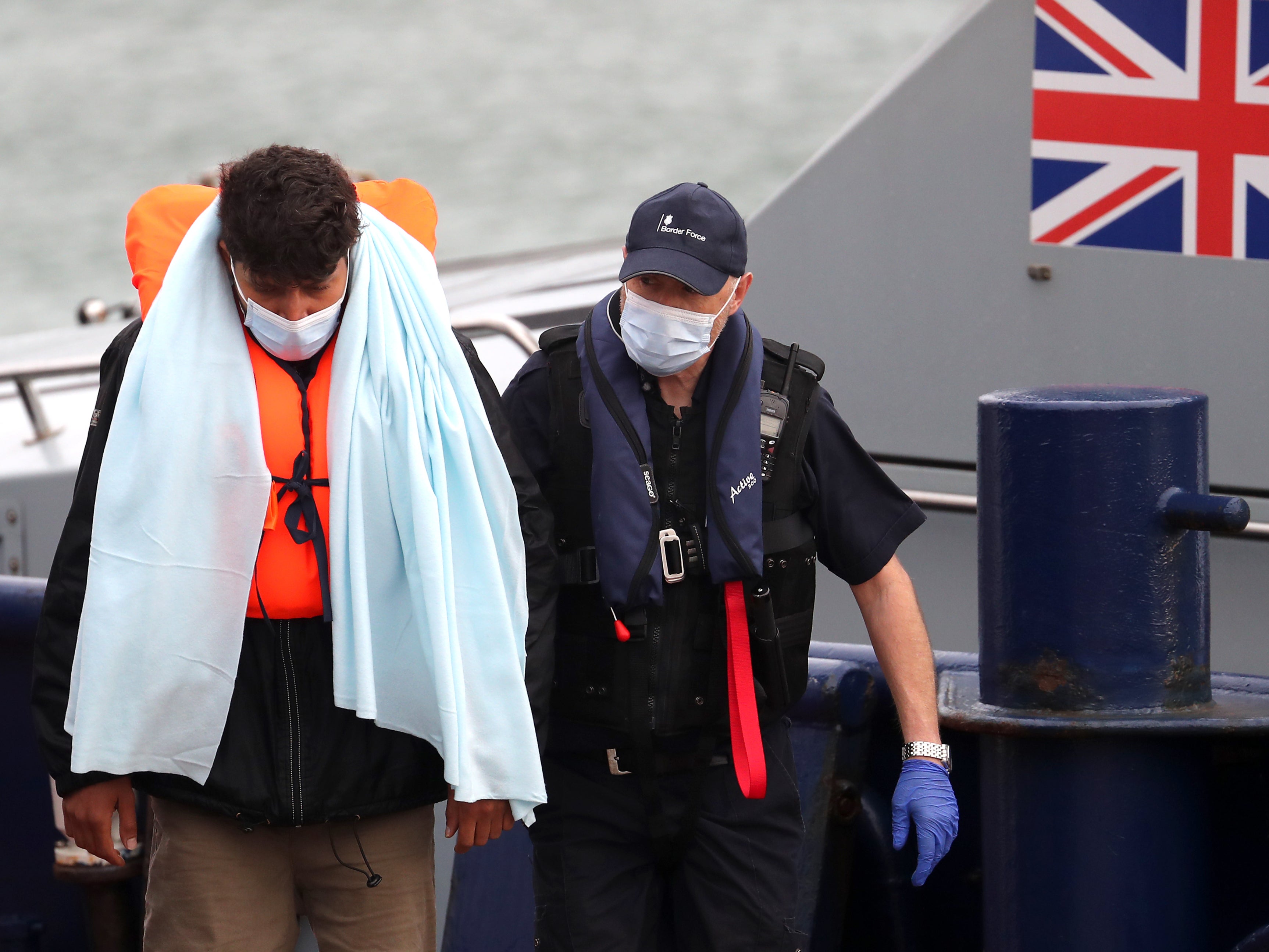 A man is brought in to Dover by Border Force officials on 3 June