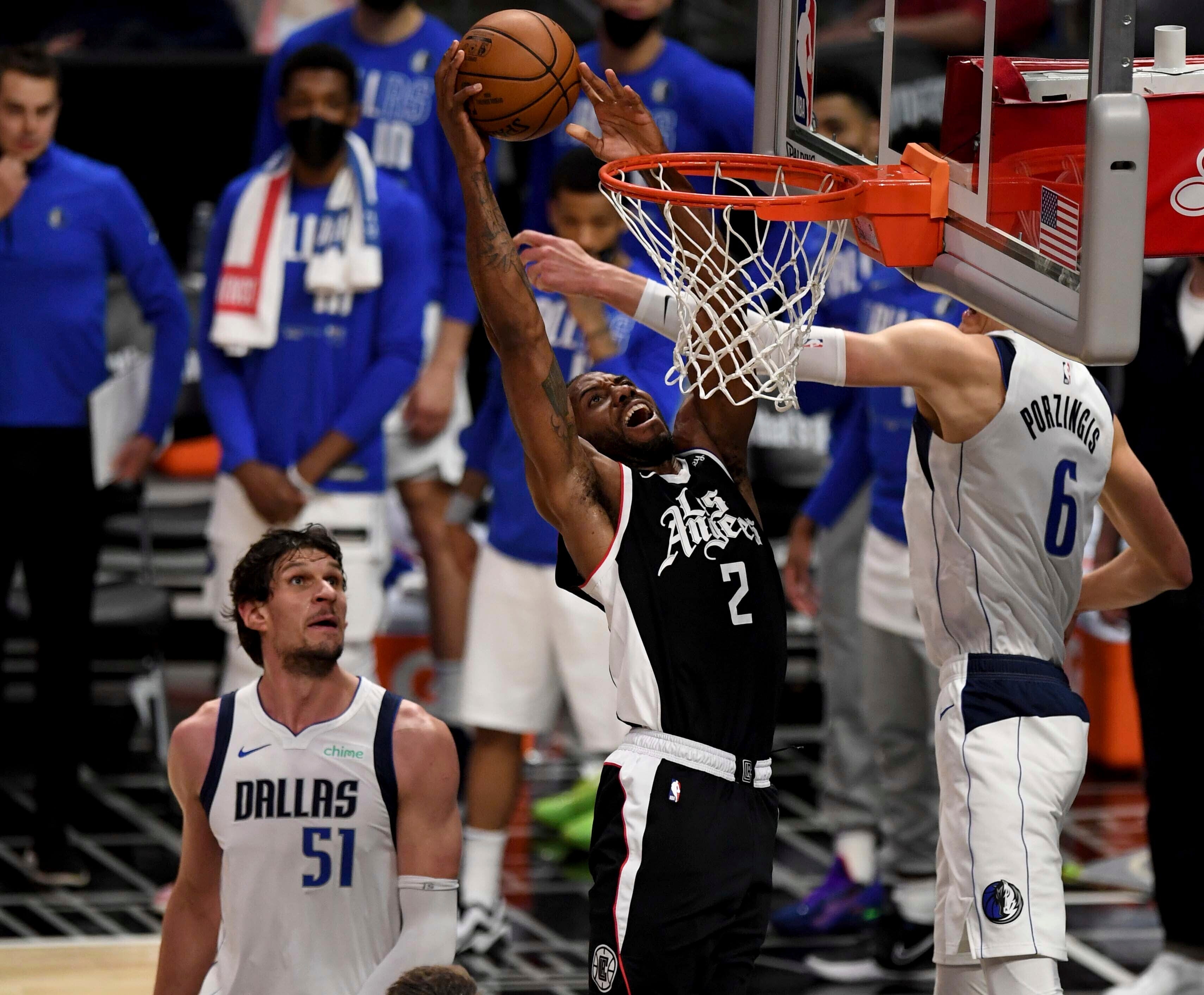 Los Angeles Clippers’ Kawhi Leonard (2) slam-dunks over Dallas Mavericks’ Kristaps Porzingis