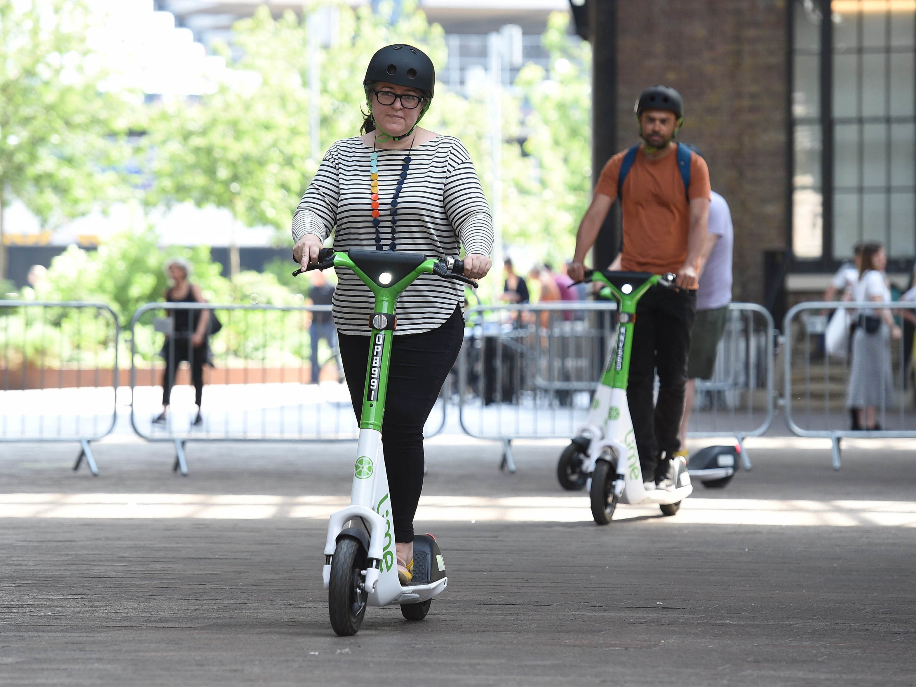 Riders use an electric scooter as Lime announces a year-long trial in partnership with TfL