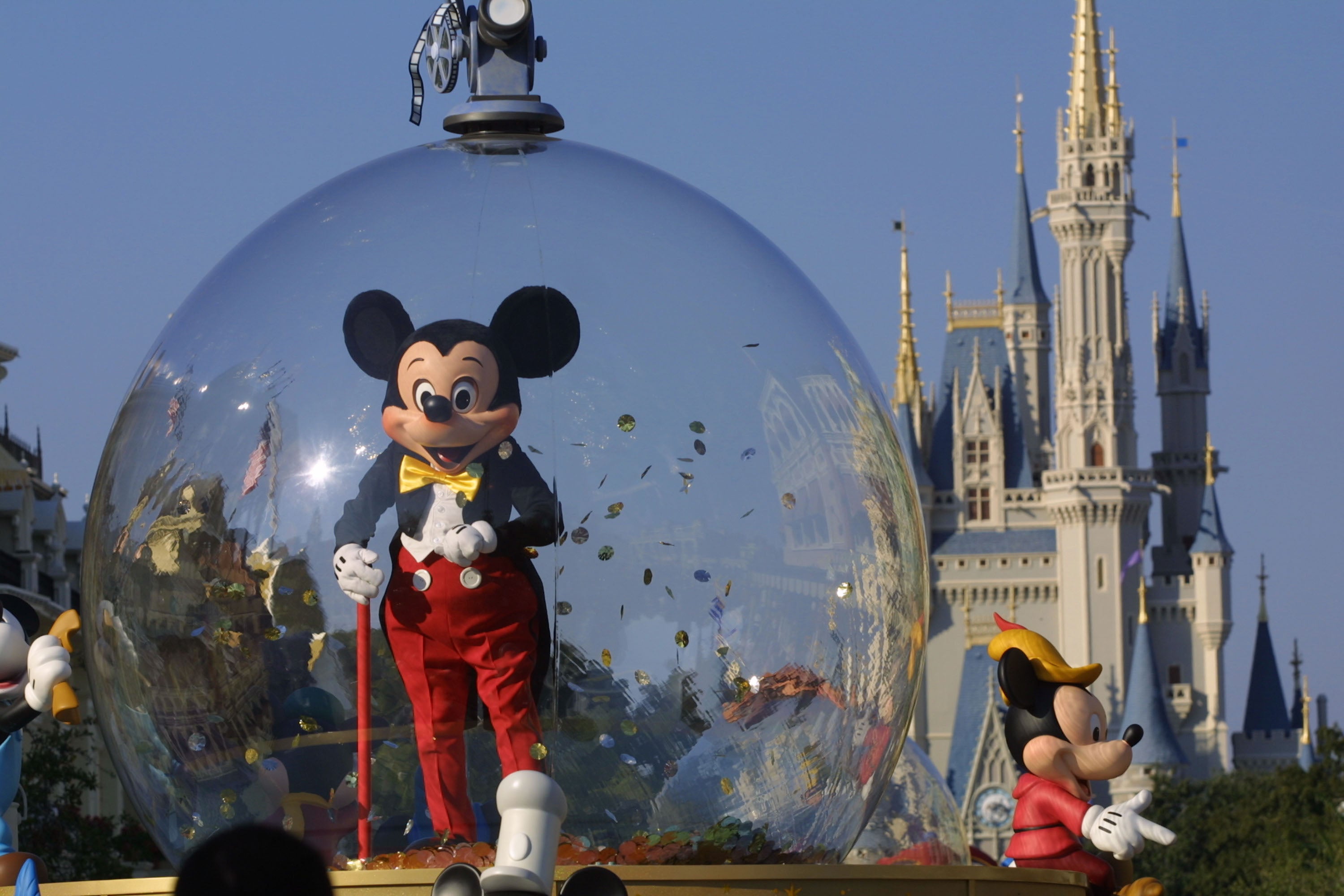 Mickey Mouse rides in a parade through Main Street, USA, with Cinderella's Castle in the background at Disney World's Magic Kingdom in Orlando, Florida