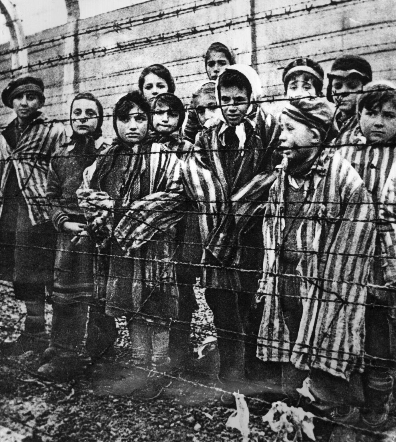 A group of child survivors behind barbed wire at Auschwitz-Birkenau in Poland, on the day of the camp’s liberation by the Red Army, 27 January 1945