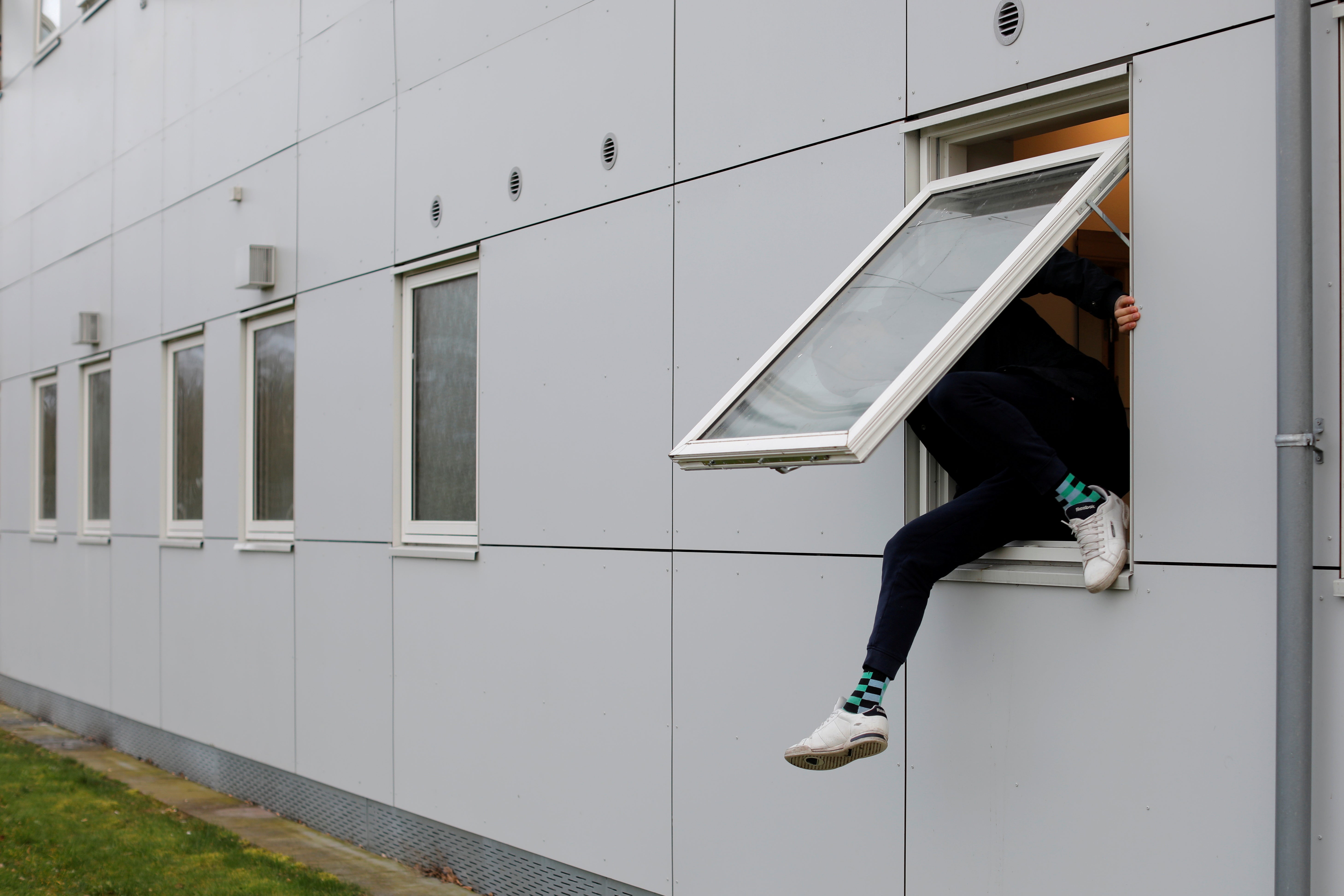 A resident climbs through a window at Kaershovedgaard