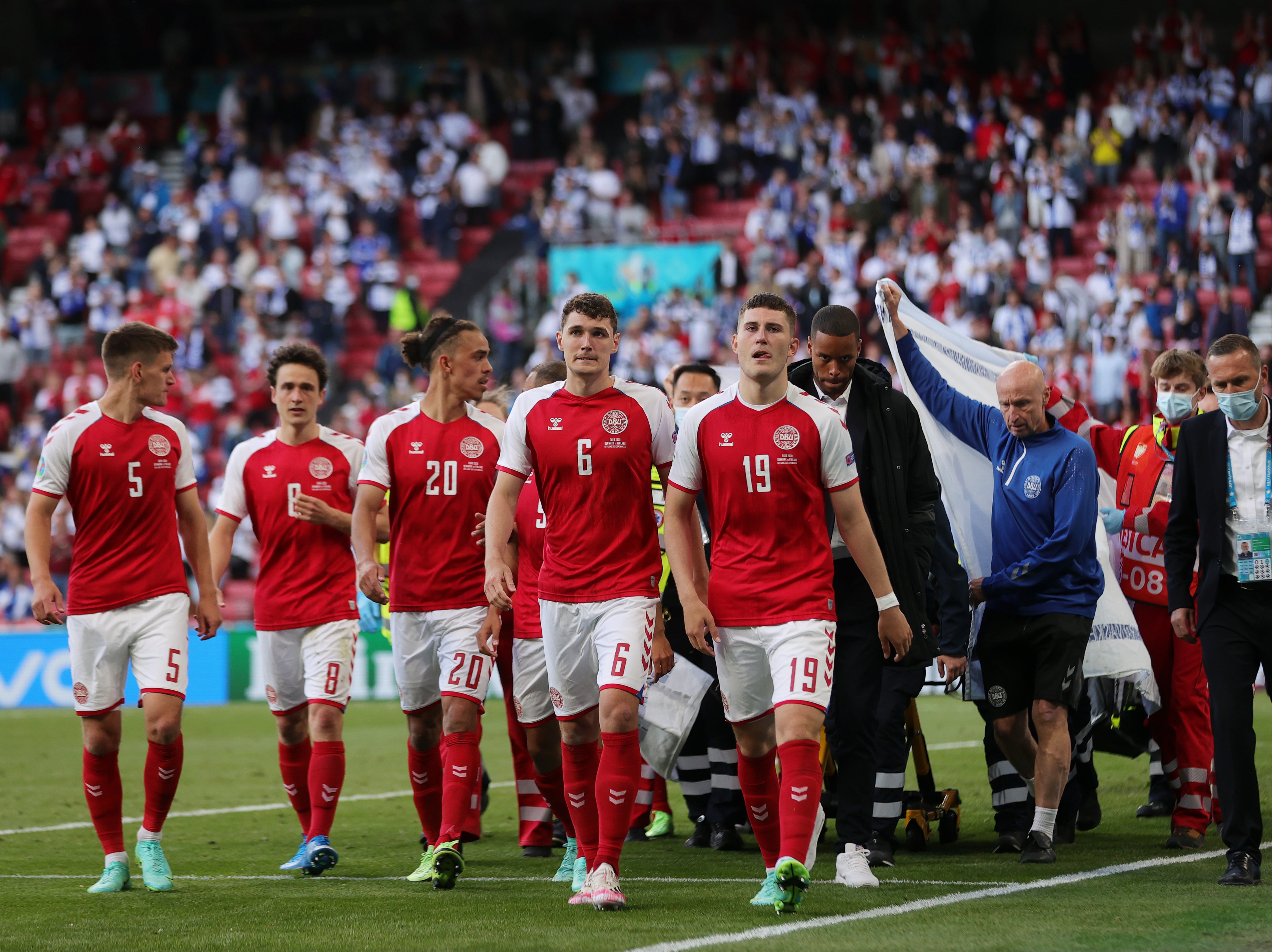 Christian Eriksen is escorted off of the field by team mates and medics on a stretcher