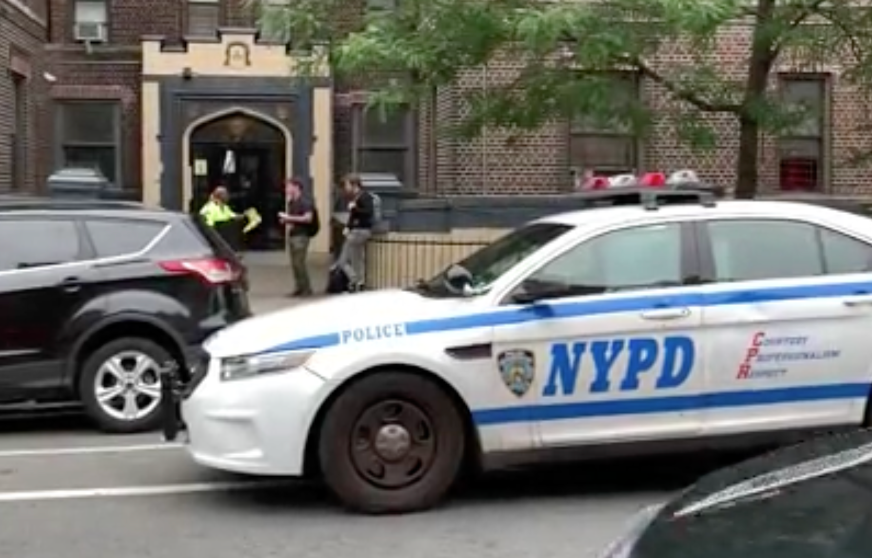 A police car sits outside the woman, who is now in hospital, who threw her kids out of the window.