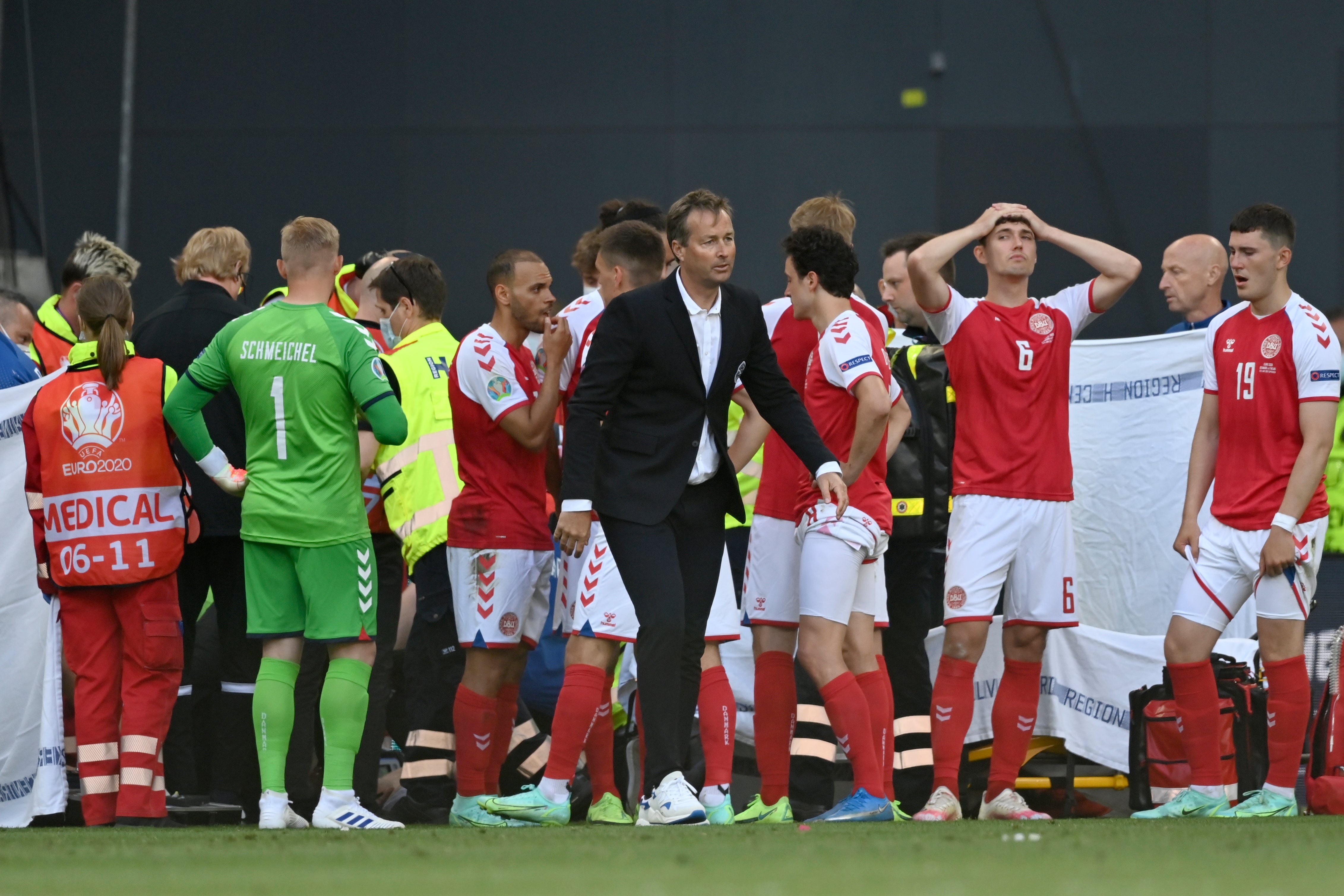 Denmark’s players look on anxiously as teammate Eriksen receives life-saving treatment during Saturday’s Euro 2020 match against Finland