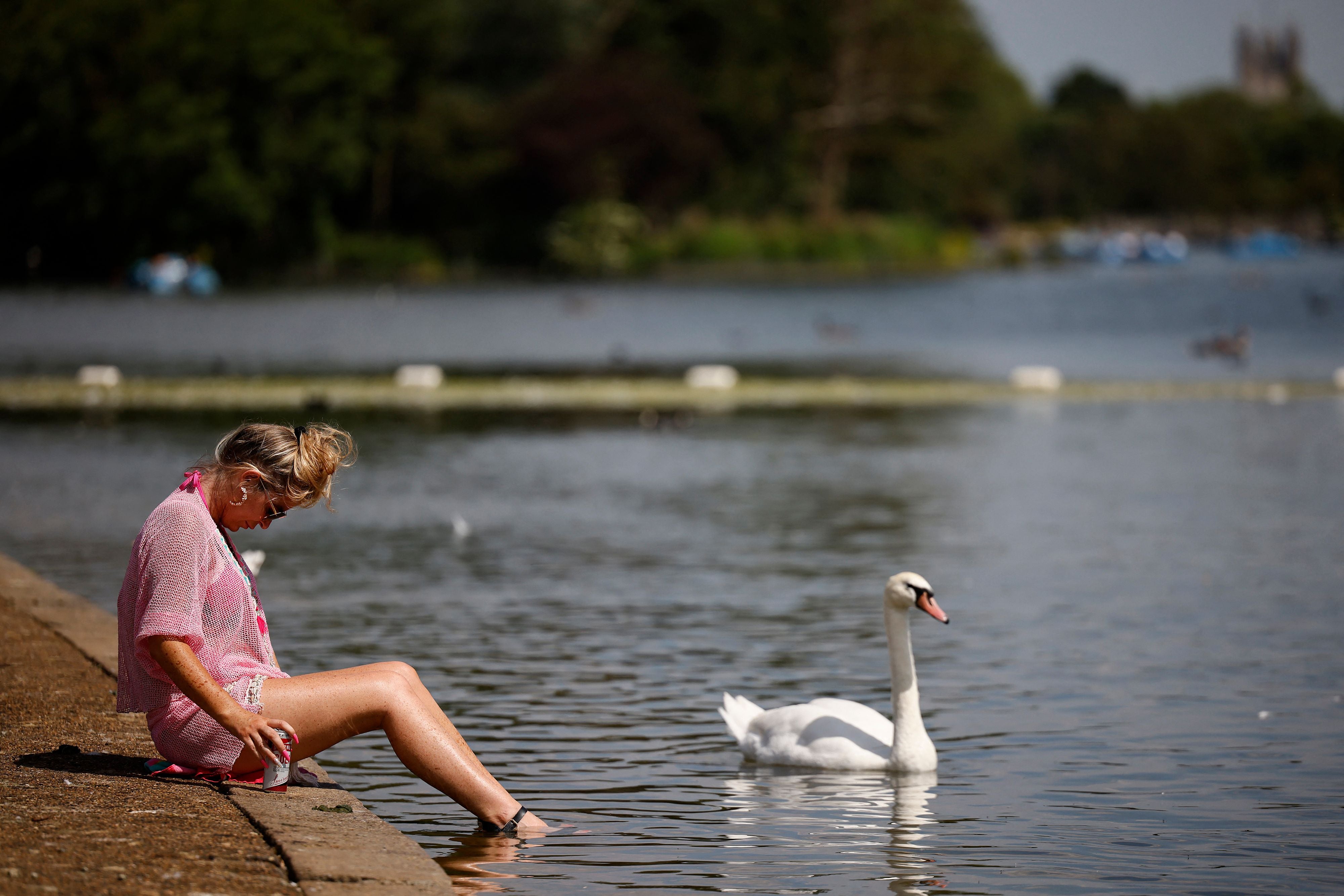 A woman paddles her feet in the Serpentine in Hyde Park