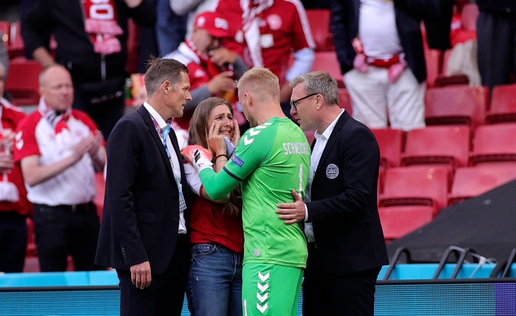 Kasper Schmeichel speaks to Christian Eriksen's wife Sabrina Kvist by the side of the pitch