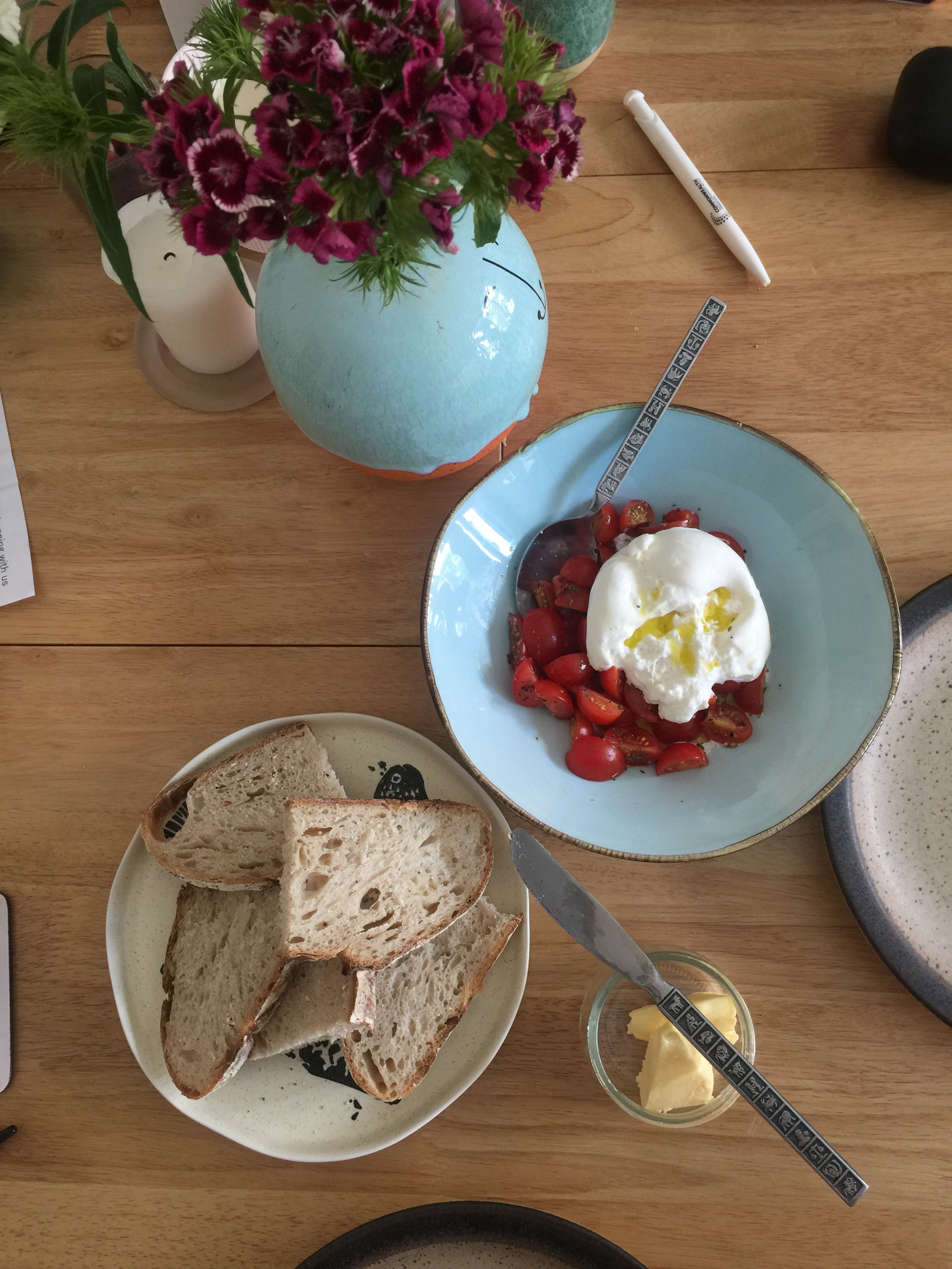 Homemade sourdough bread with burrata over fresh cherry tomatoes