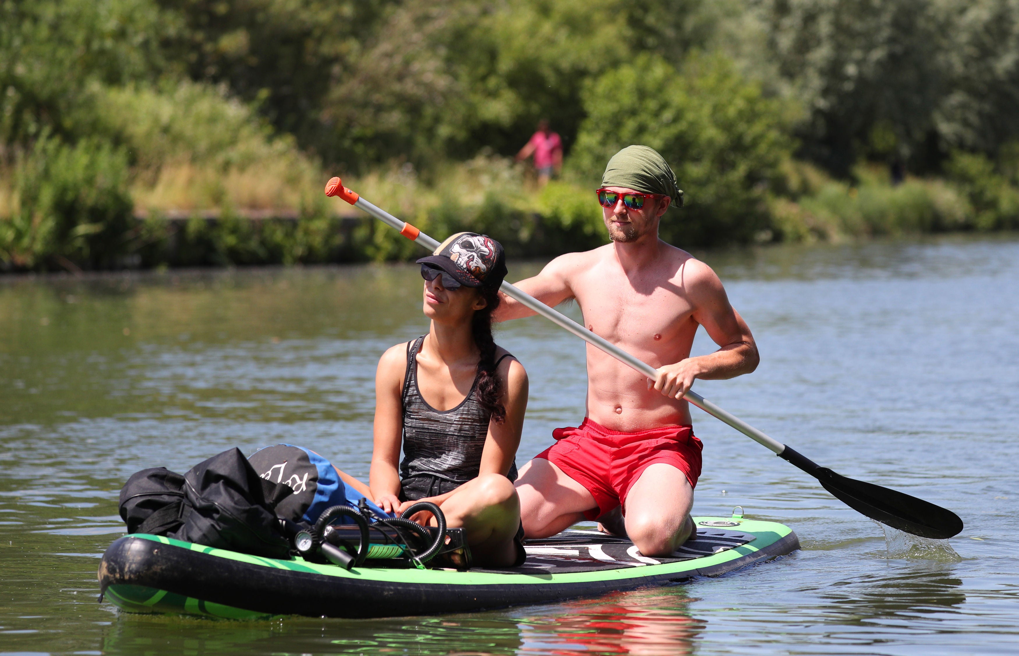 A pair of paddle boarders travel along the River Thames by the Riverside Centre near Donnington Bridge, Oxford