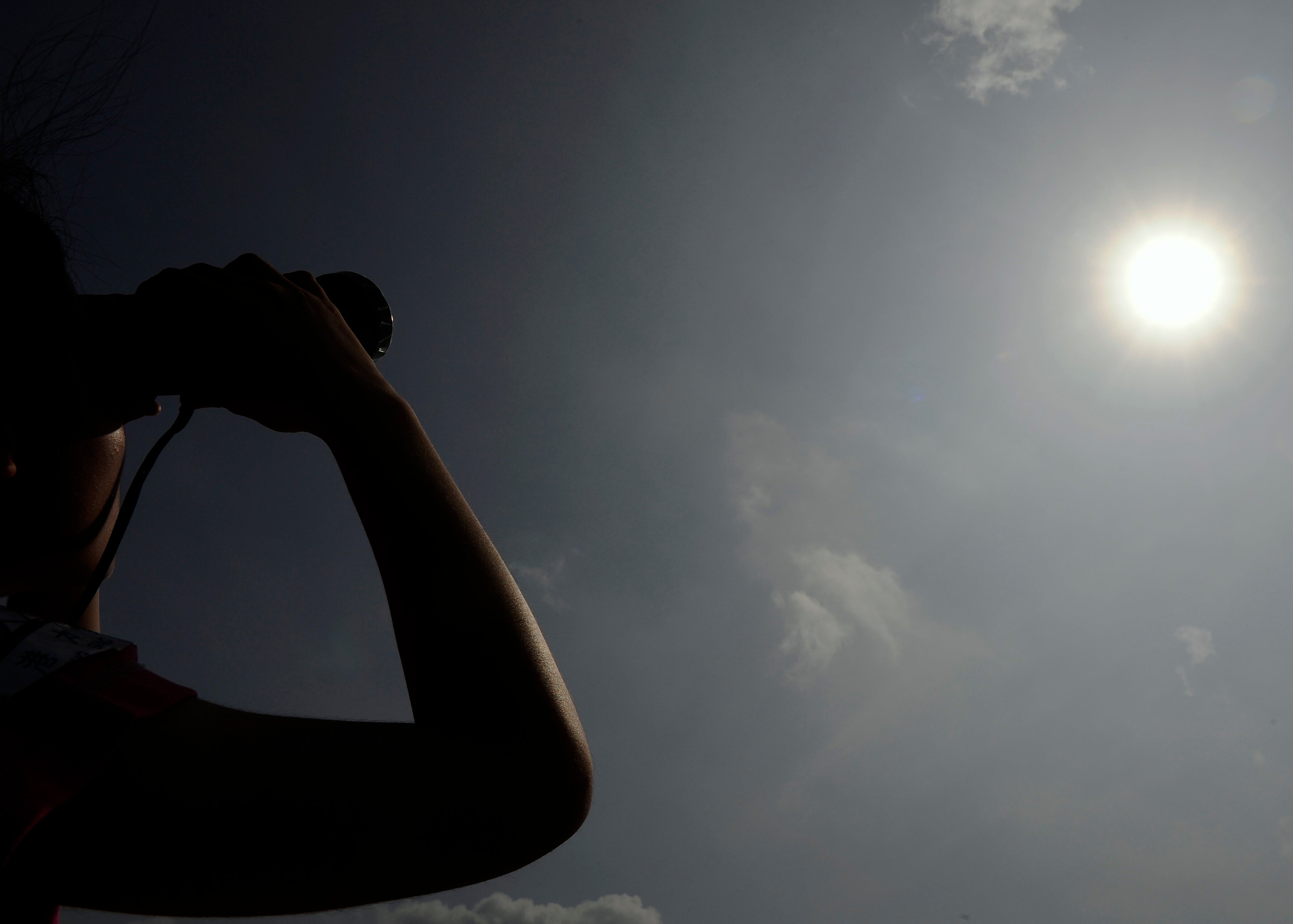 File image: A woman in Hong Kong looks through binoculars as planet Venus orbits between the Sun and the Earth during the transit of Venus on 6 June, 2012. Earth’s energy imbalance is the difference between the amount of energy it receives and from sun and radiates back