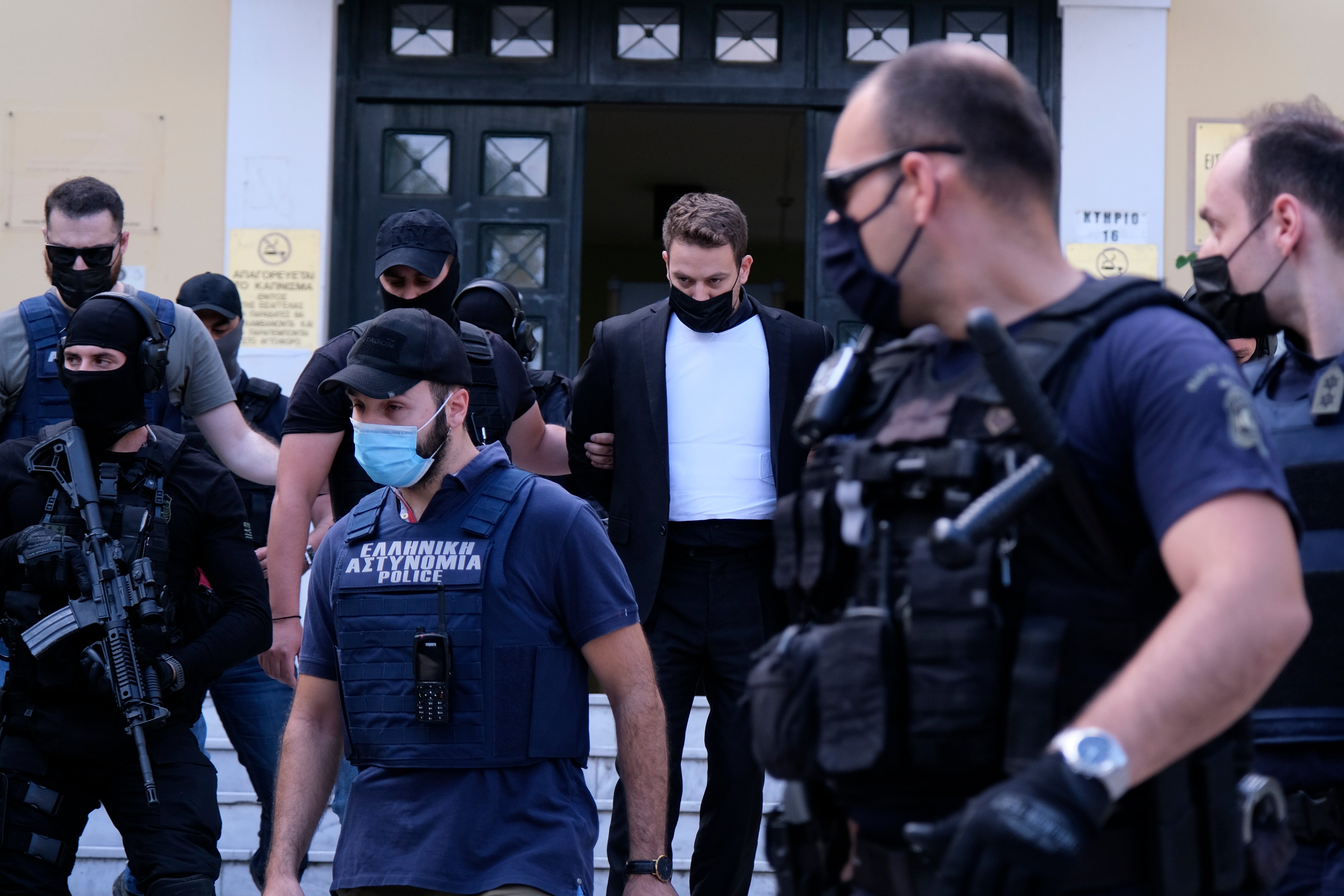 Babis Anagnostopoulos, escorted by police, leaves the court in Athens