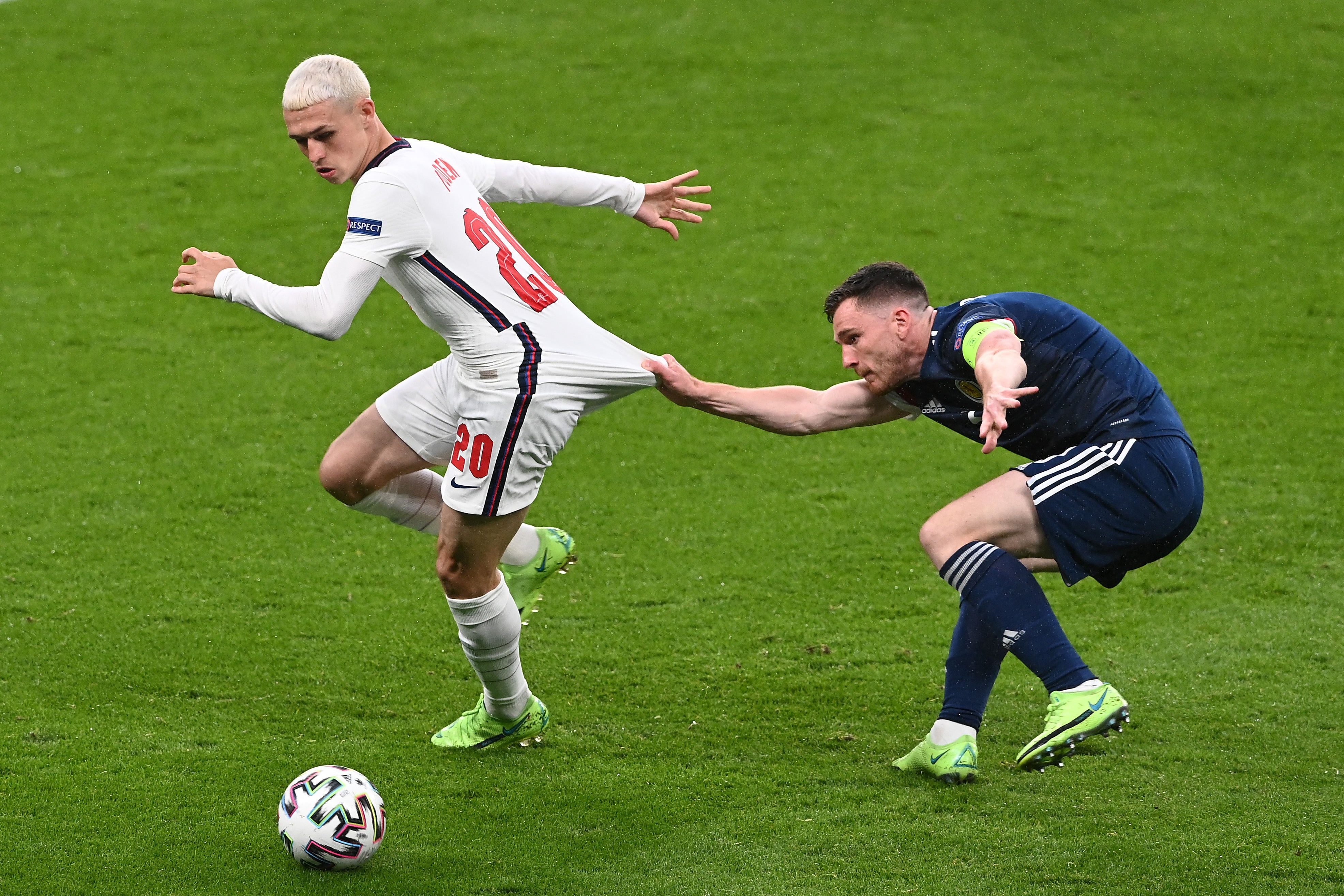 Phil Foden being pulled back by Andrew Robertson