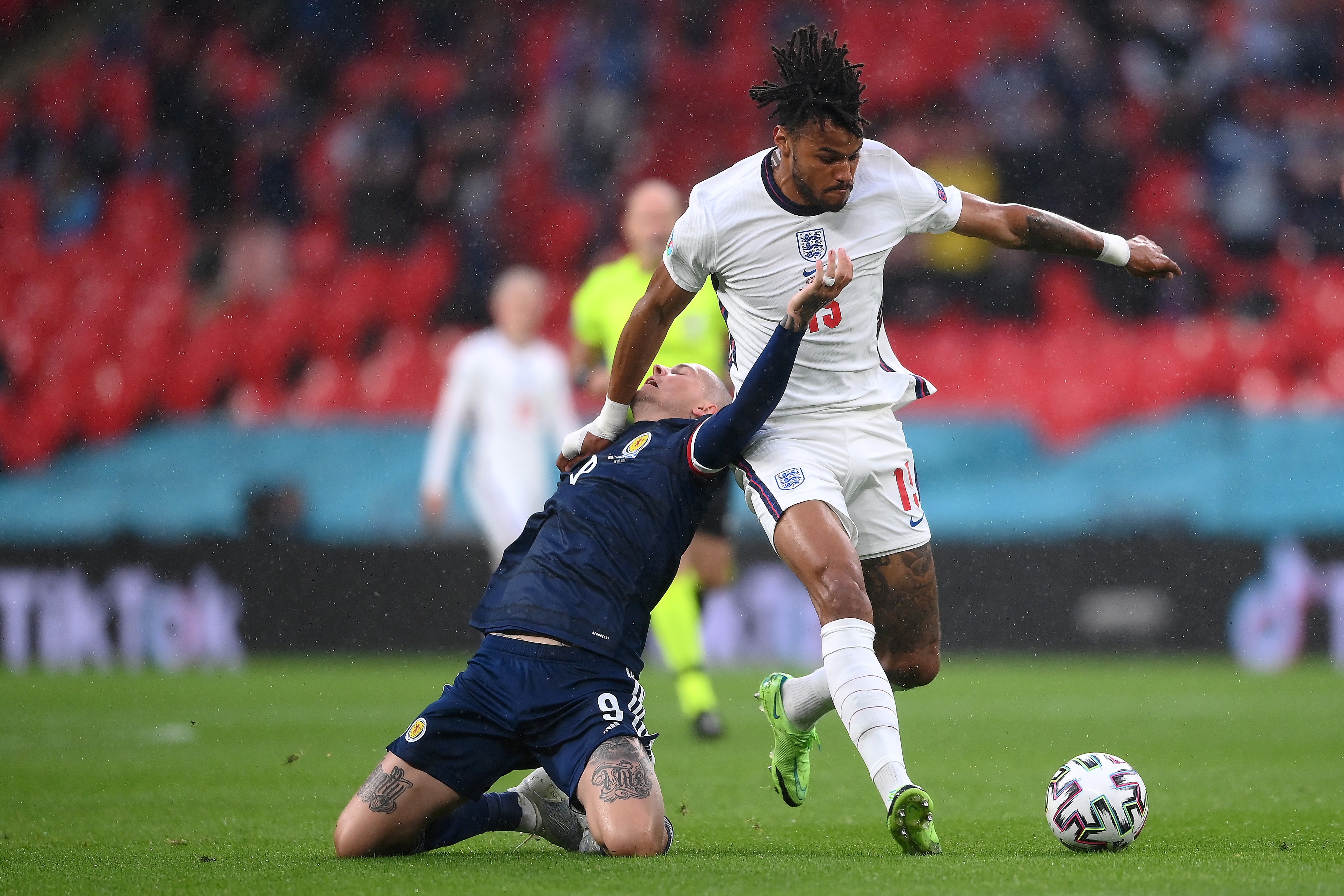 Lyndon Dykes is challenged by Tyrone Mings