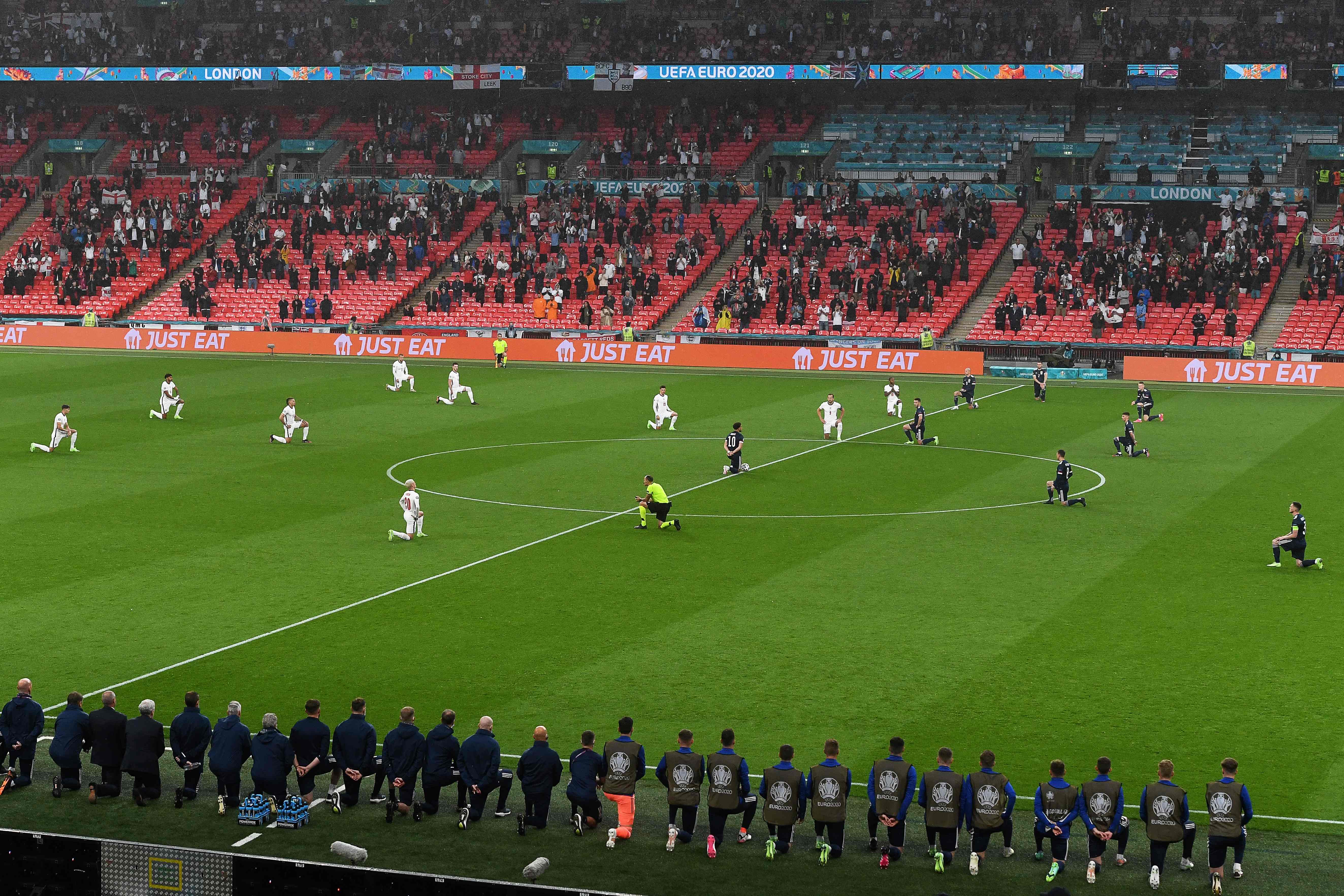 Players kneel down before the match