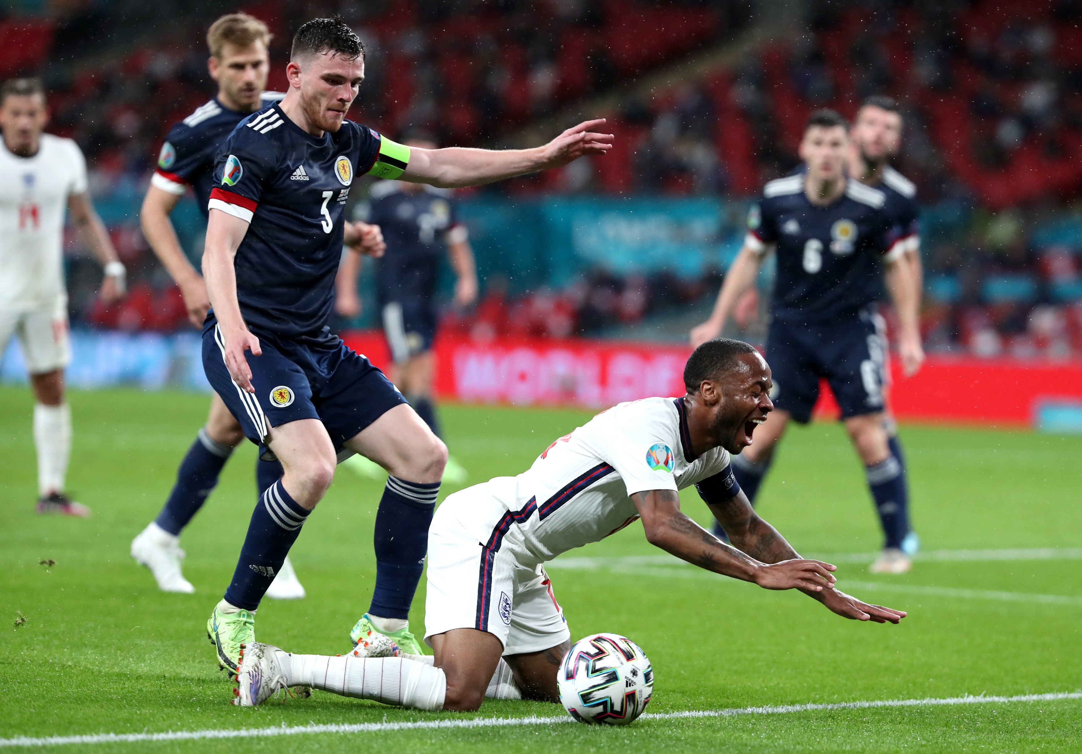 Raheem Sterling reacts after a tackle by Andrew Robertson