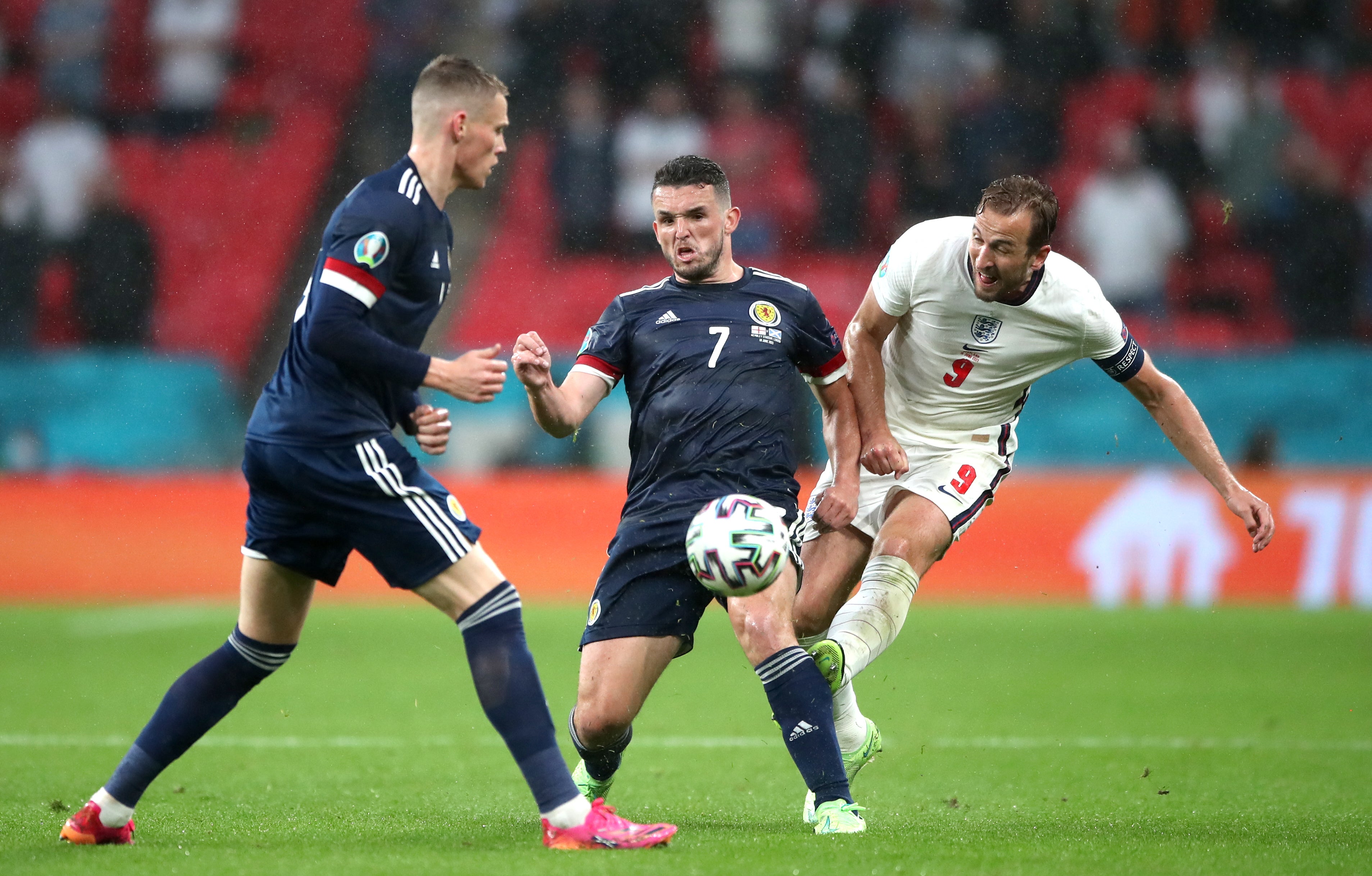 Harry Kane, right, is crowded out by Scotland’s John McGinn, centre, and Scott McTominay