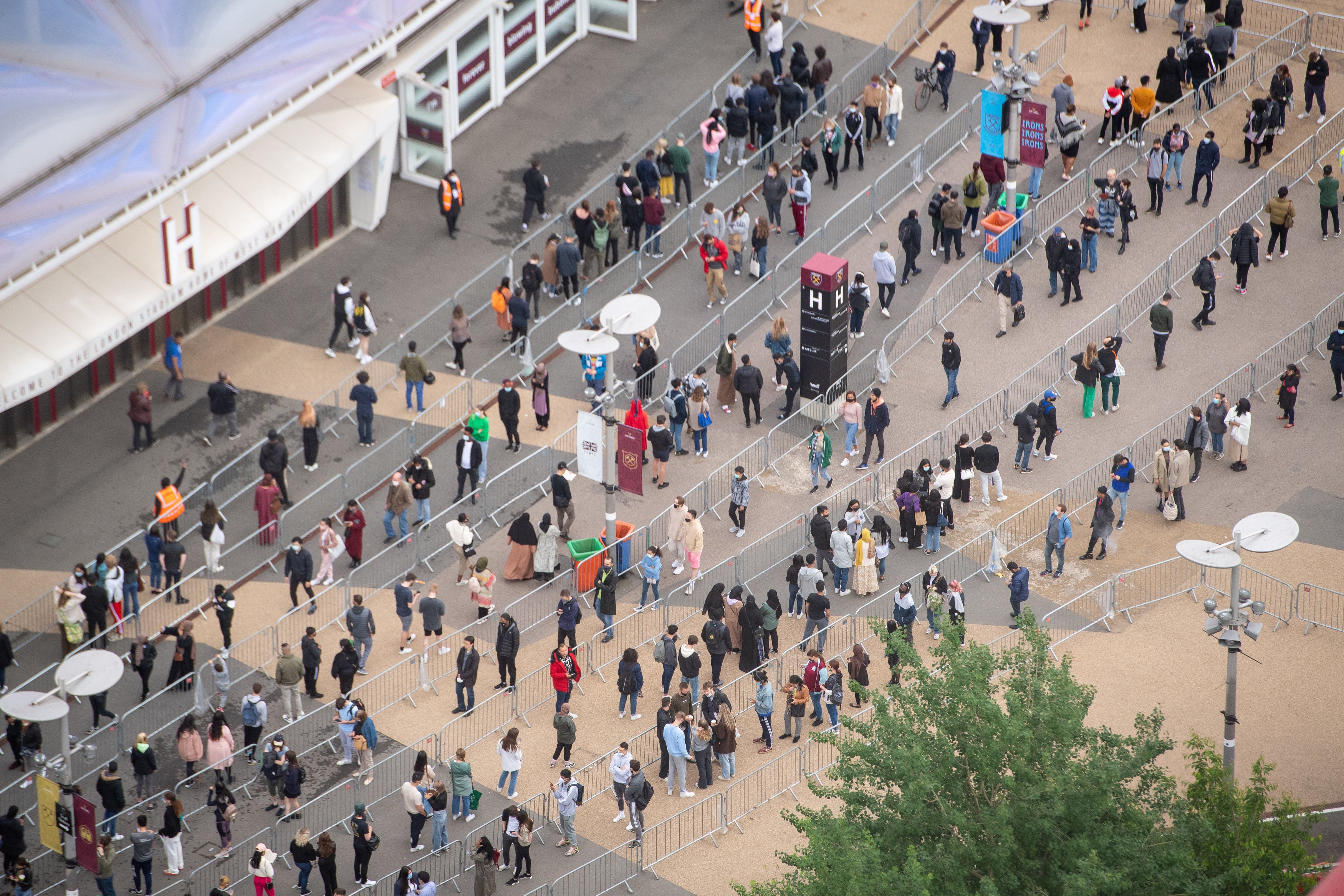 People queue outside an NHS vaccination clinic at West Ham’s London Stadium