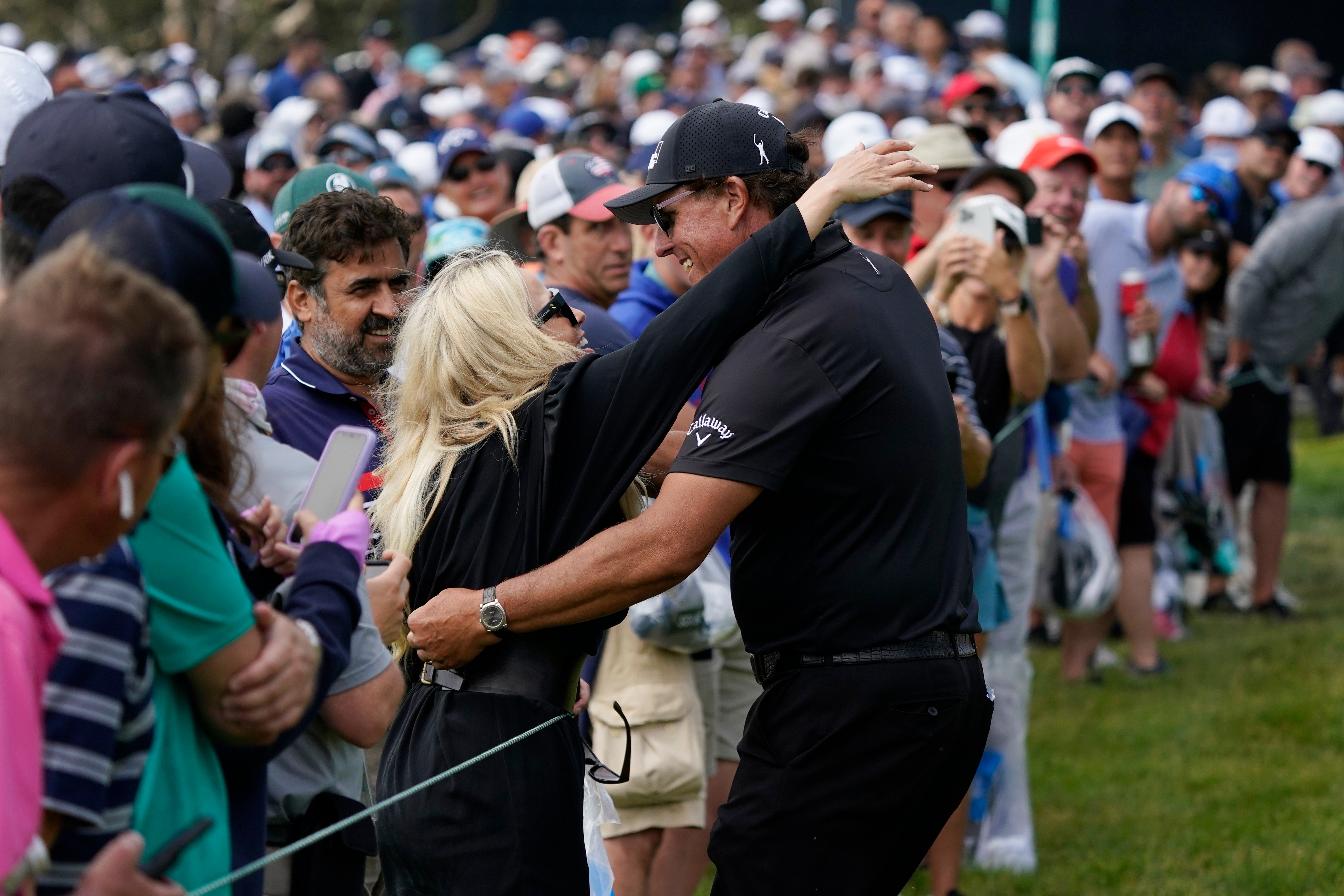 Phil Mickelson hugs his wife, Amy, on the seventh fairway