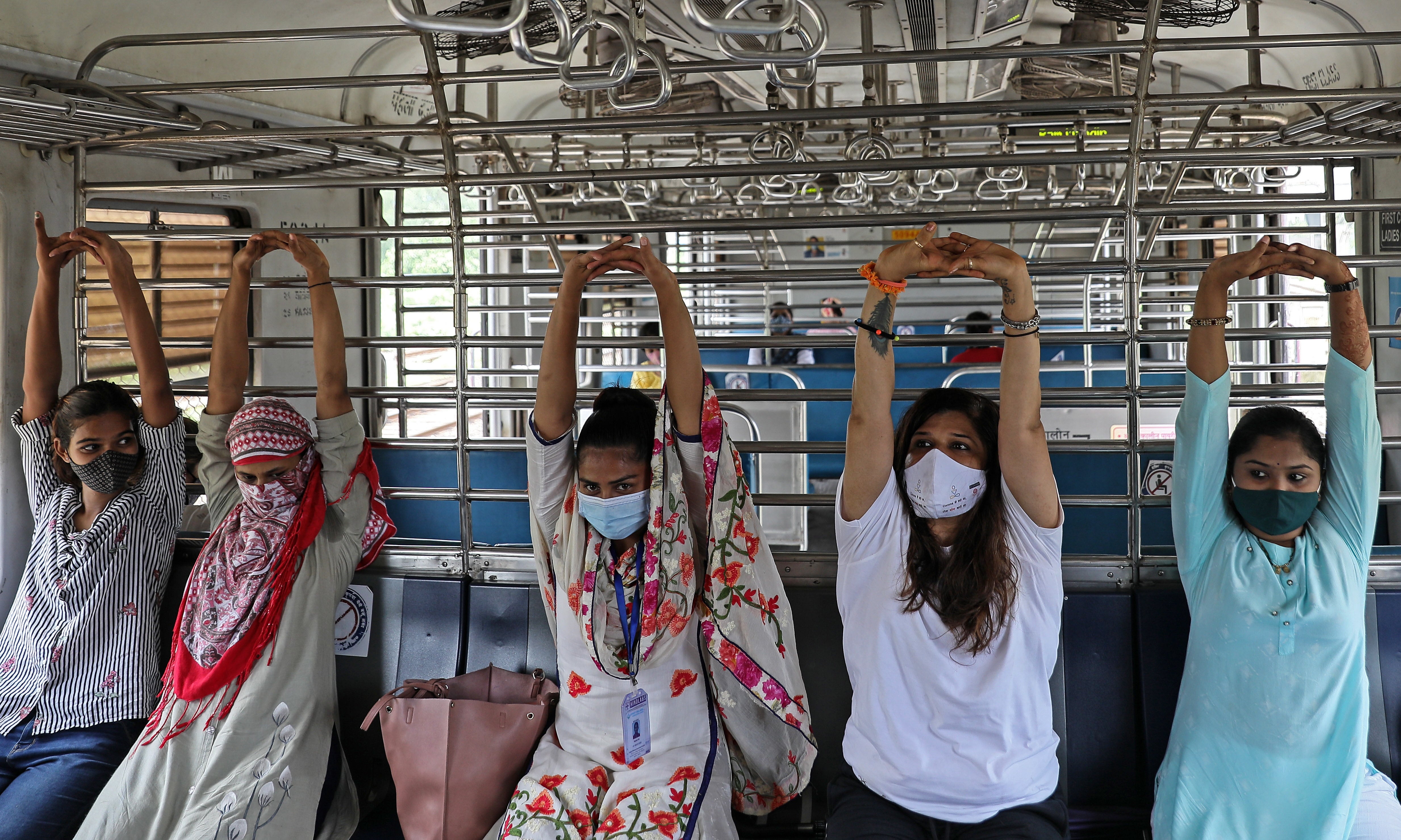Women perform yoga inside a local train in Mumbai.