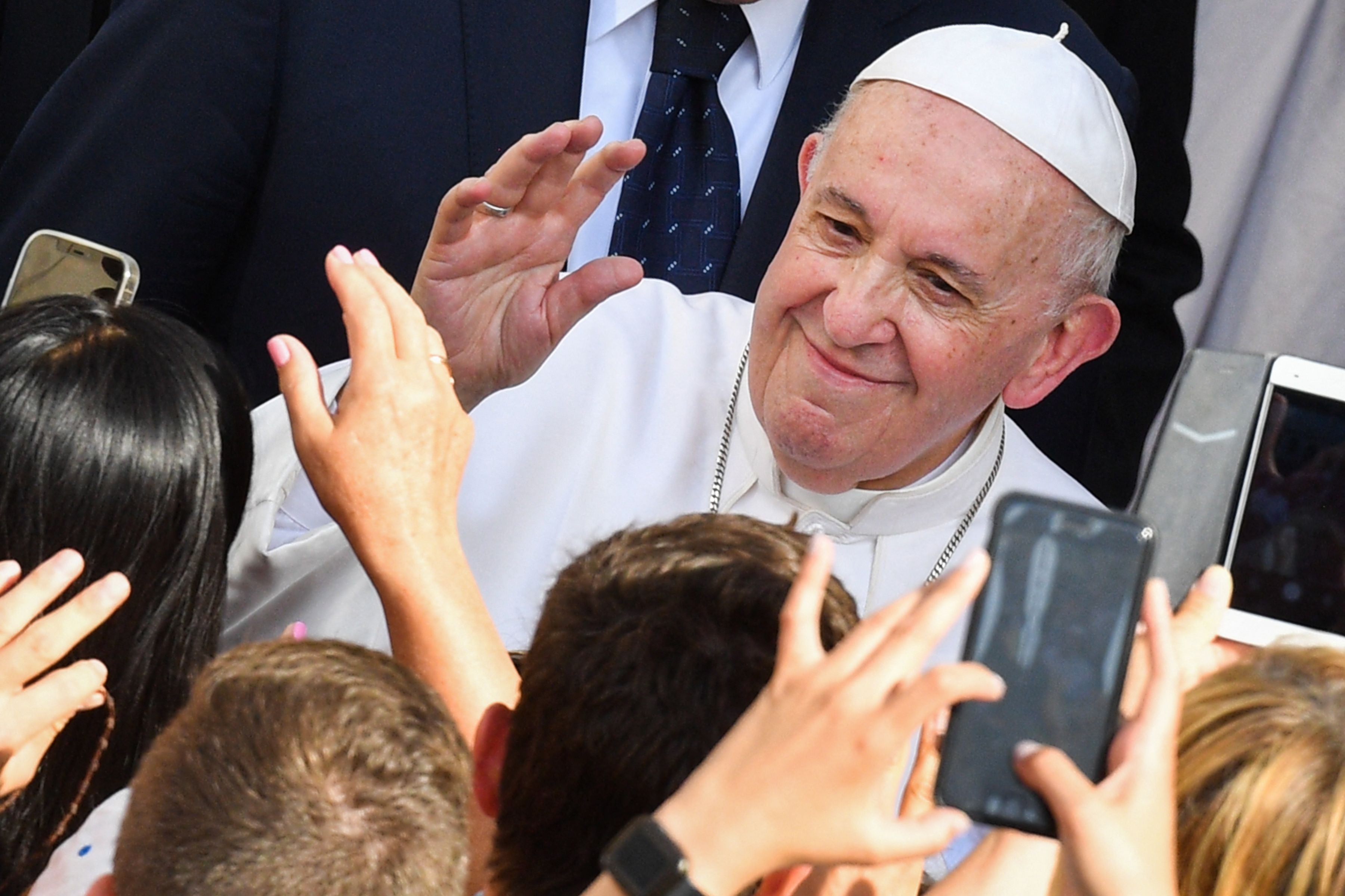 Attendees greet Pope Francis as he arrives to hold his weekly general audience at San Damaso courtyard in The Vatican