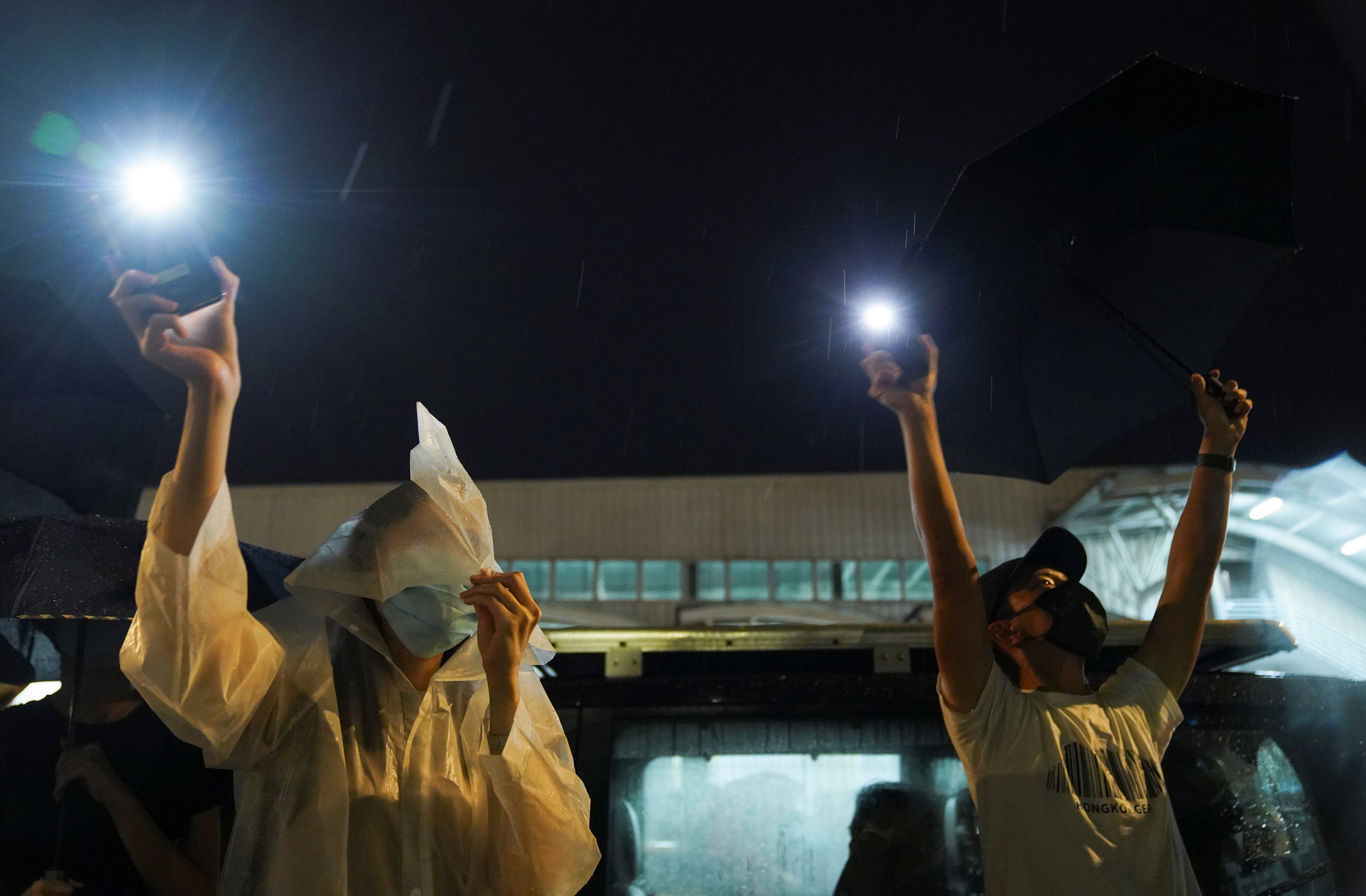 Supporters light their phone flashlights outside the offices of Apple Daily and its publisher Next Digital, after the announcement that it would print its last edition this week