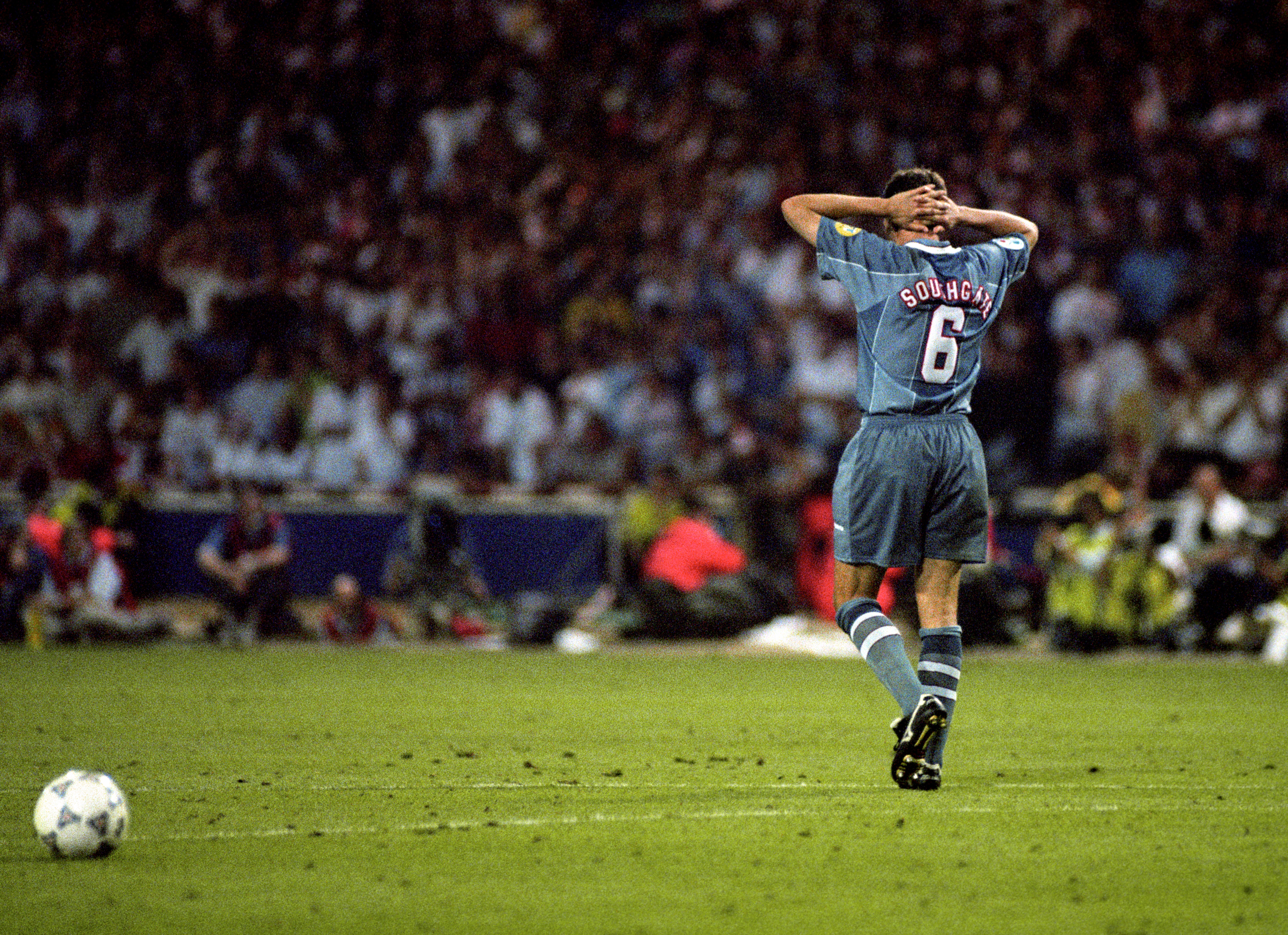 Gareth Southgate stands with his hands behind his head after missing a penalty