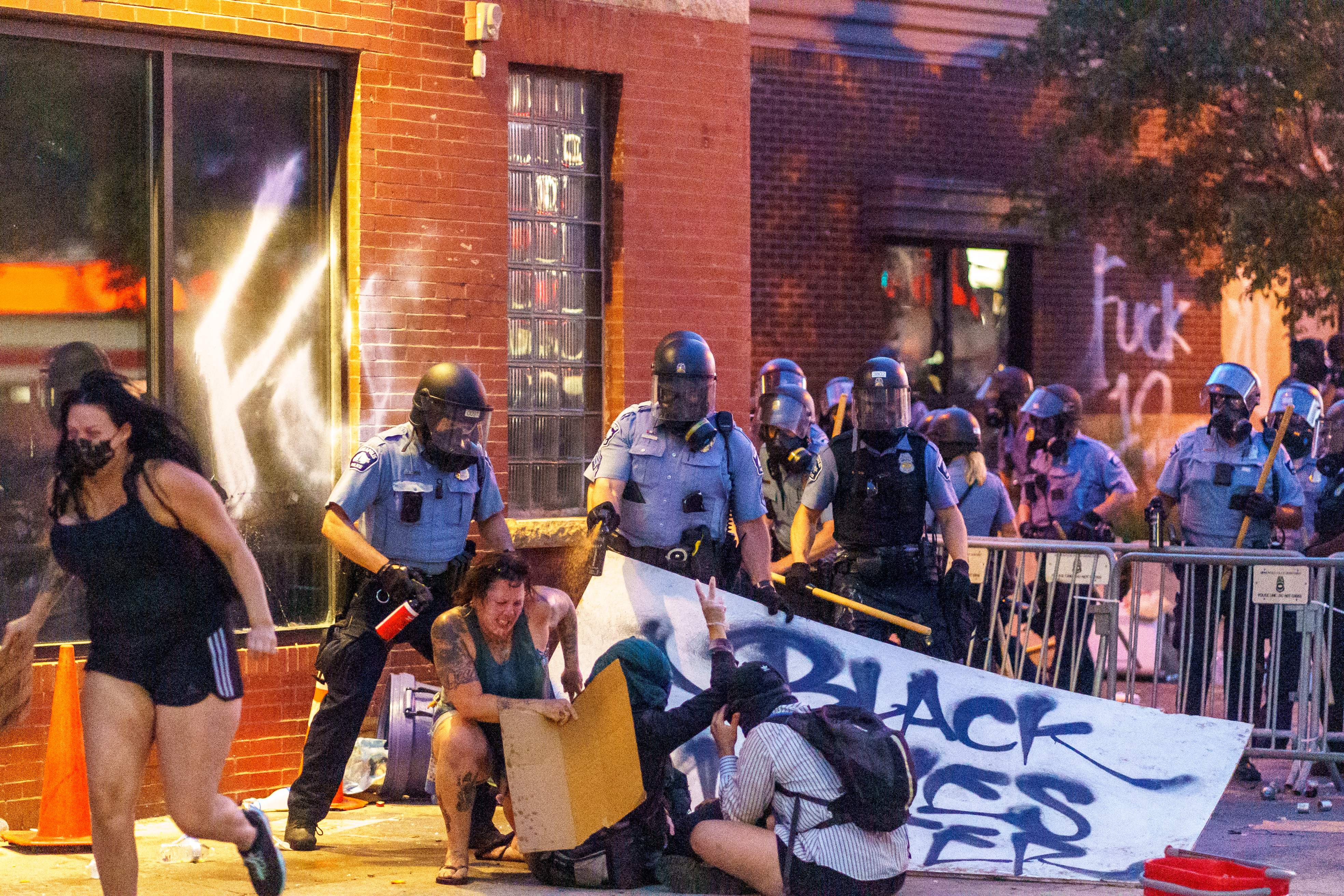 Police douse protesters with pepper spray during a demonstration over the killing of George Floyd