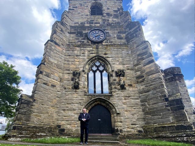 <p>Church treasurer and local historian Peter Beck outside the church clock tower</p>