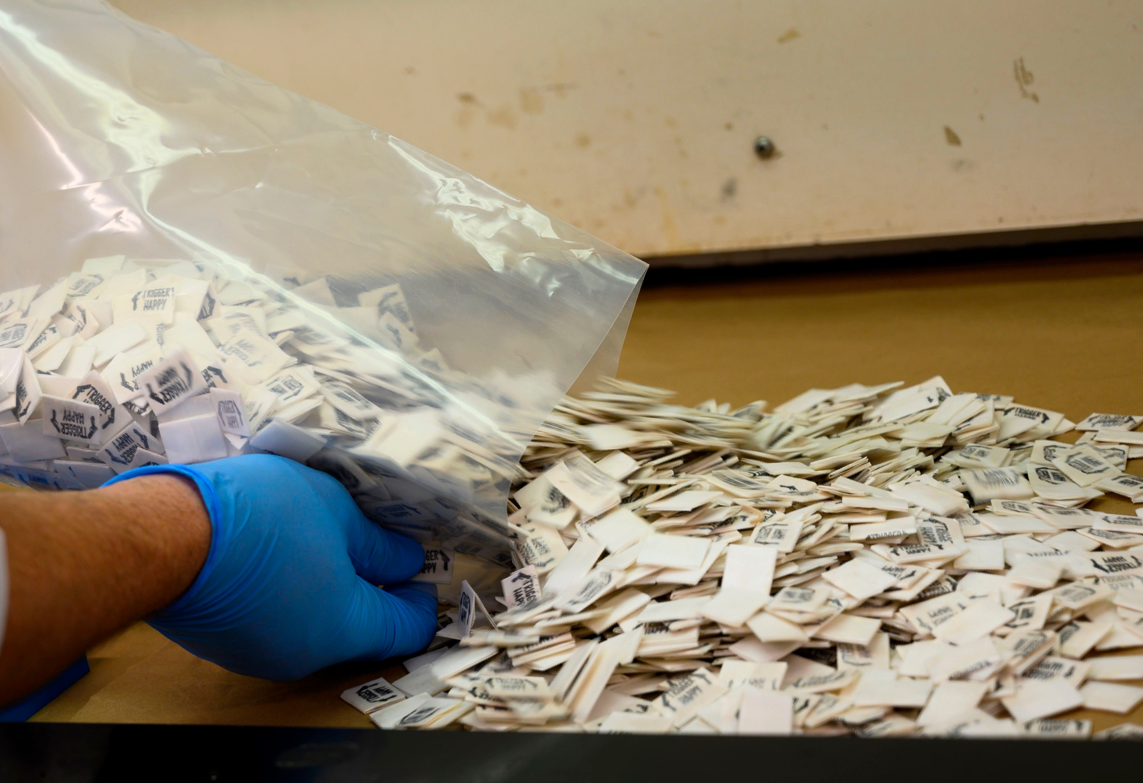 A Drug Enforcement Administration (DEA) chemist pours 2,500 packs of confirmed fentanyl onto a counter for testing at the DEA Northeast Regional Laboratory in New York