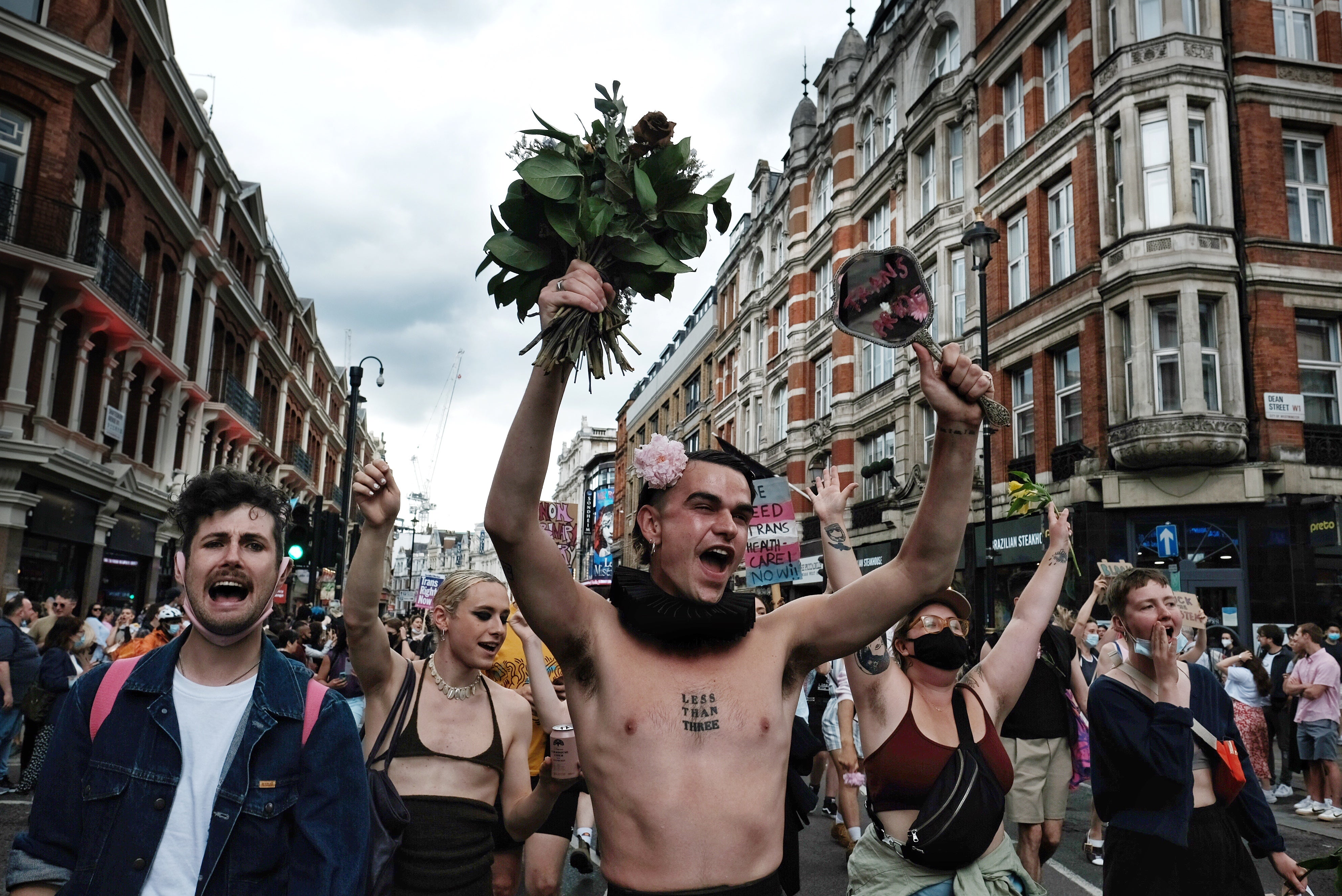 One marcher waves flowers in London’s Soho