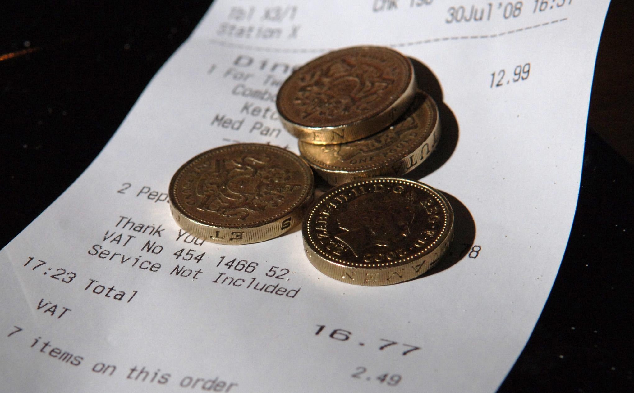 Pound coins on top of a restaurant bill