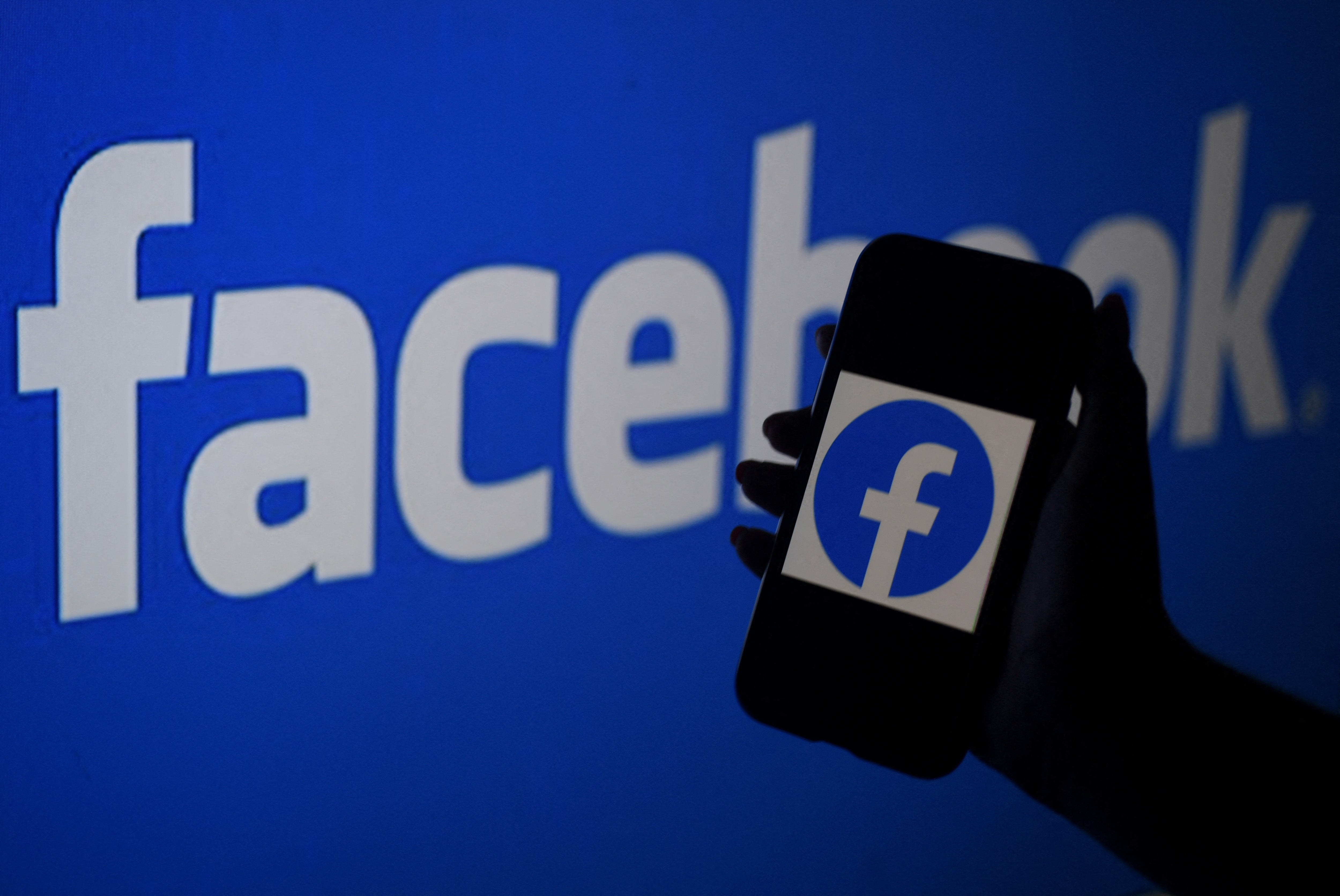 A smart phone screen displays the logo of Facebook on a Facebook website background, on 7 April, 2021, in Arlington, Virginia. A judge has dismissed two antitrust suits against the social networking giant.