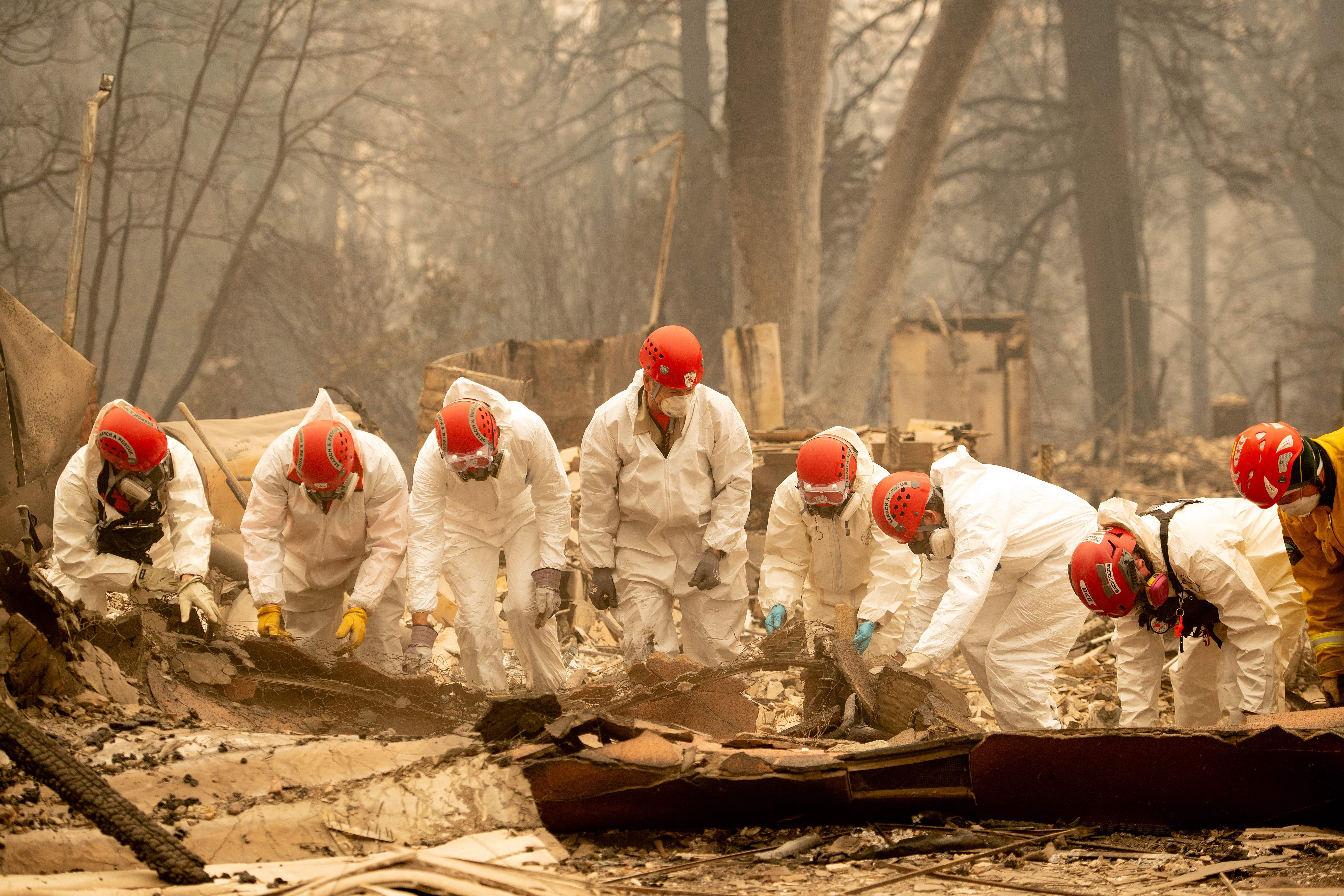 Rescue workers sift through the remains of a building in Paradise, California