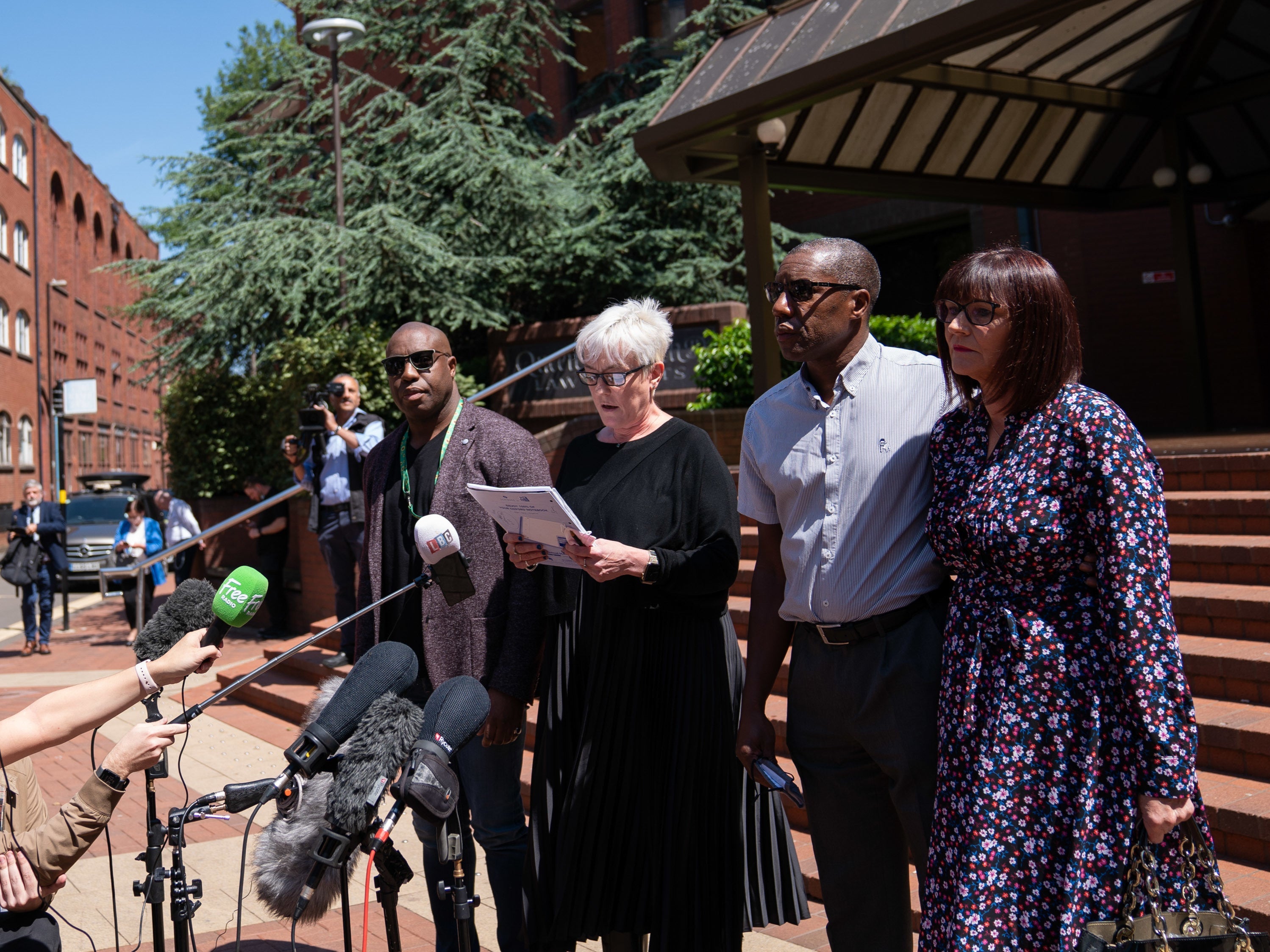 Legal representatives for the Atkinson family read a statement alongside Kenroy, brother of Dalian, and his wife Julie, right, outside Birmingham Crown Court