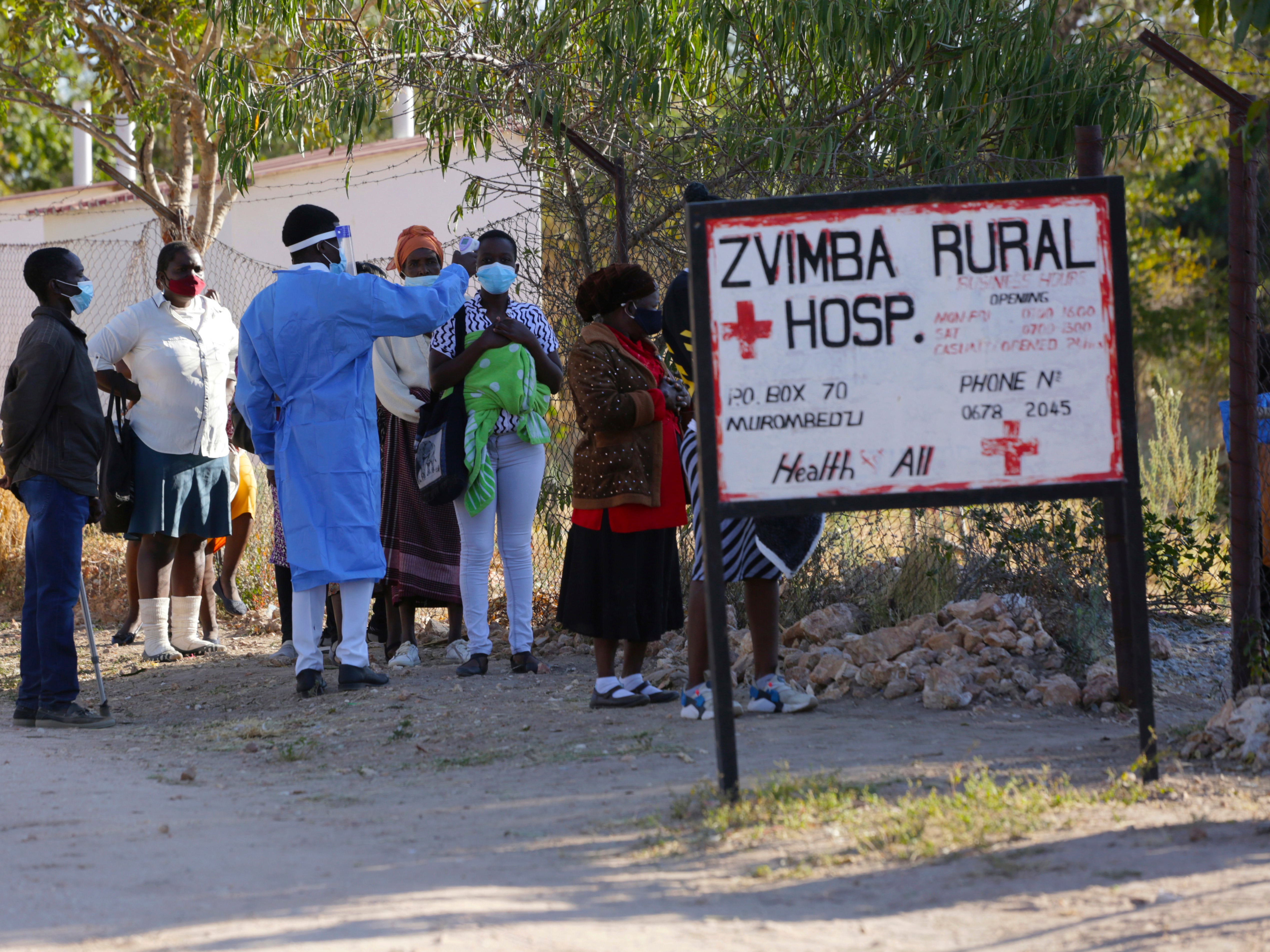 Residents of Zvimba in rural Zimbabwe have their temperatures taken before seeking treatment at the local hospital