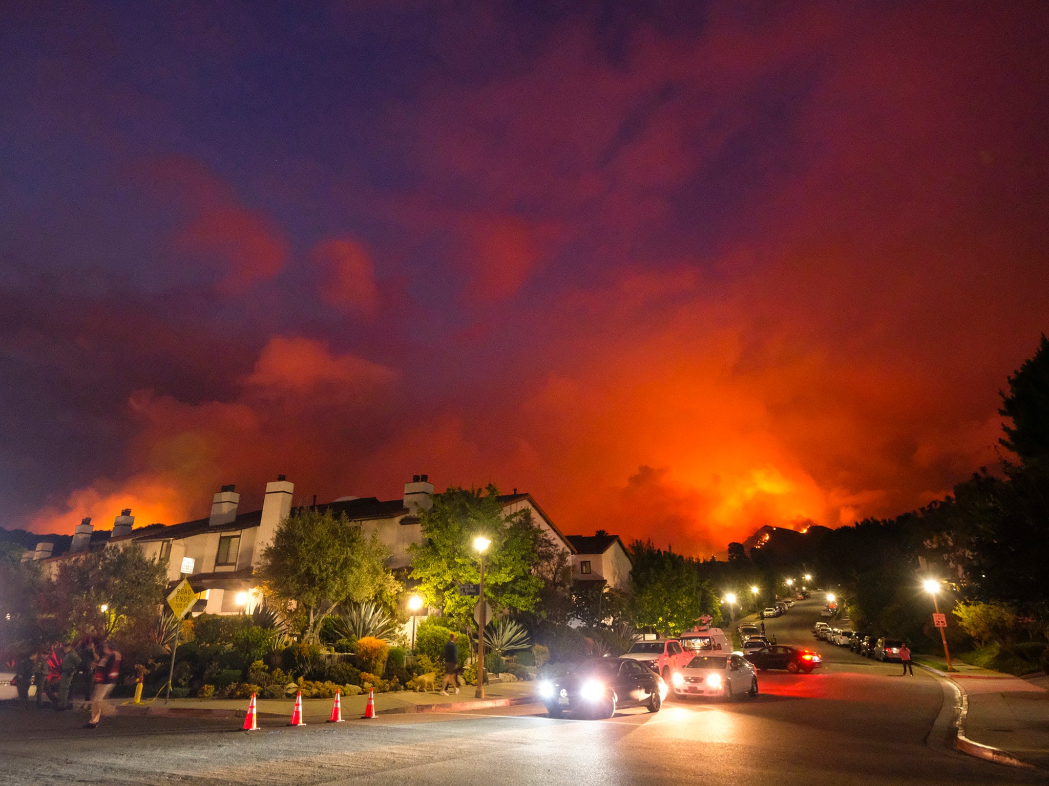 Smoke rises behind homes in Pacific Palisades last month