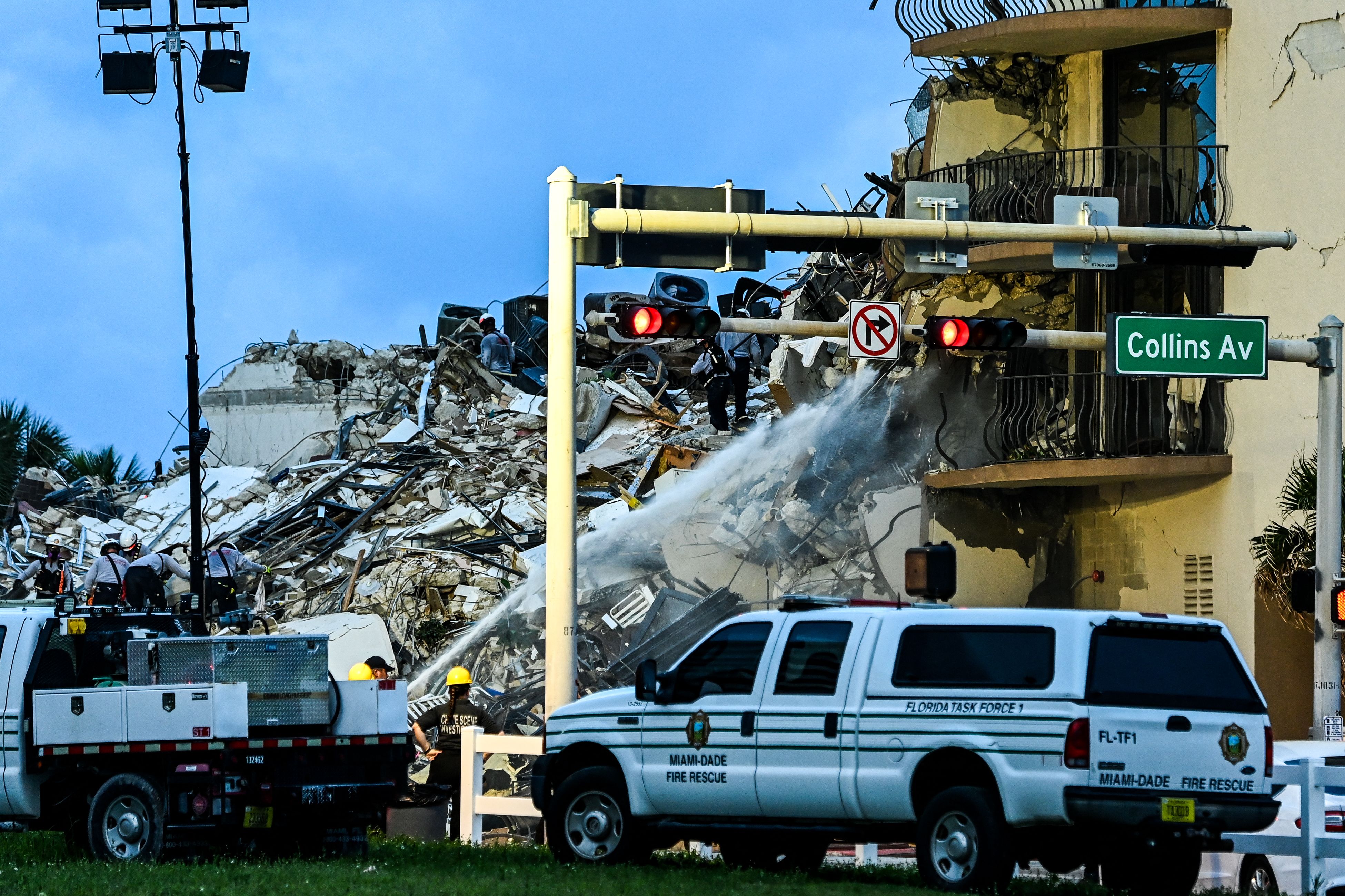 Search and Rescue personnel work as Miami Dade firefighters spray water at a partial collapse building in Surfside, Miami Beach, on June 24, 2021