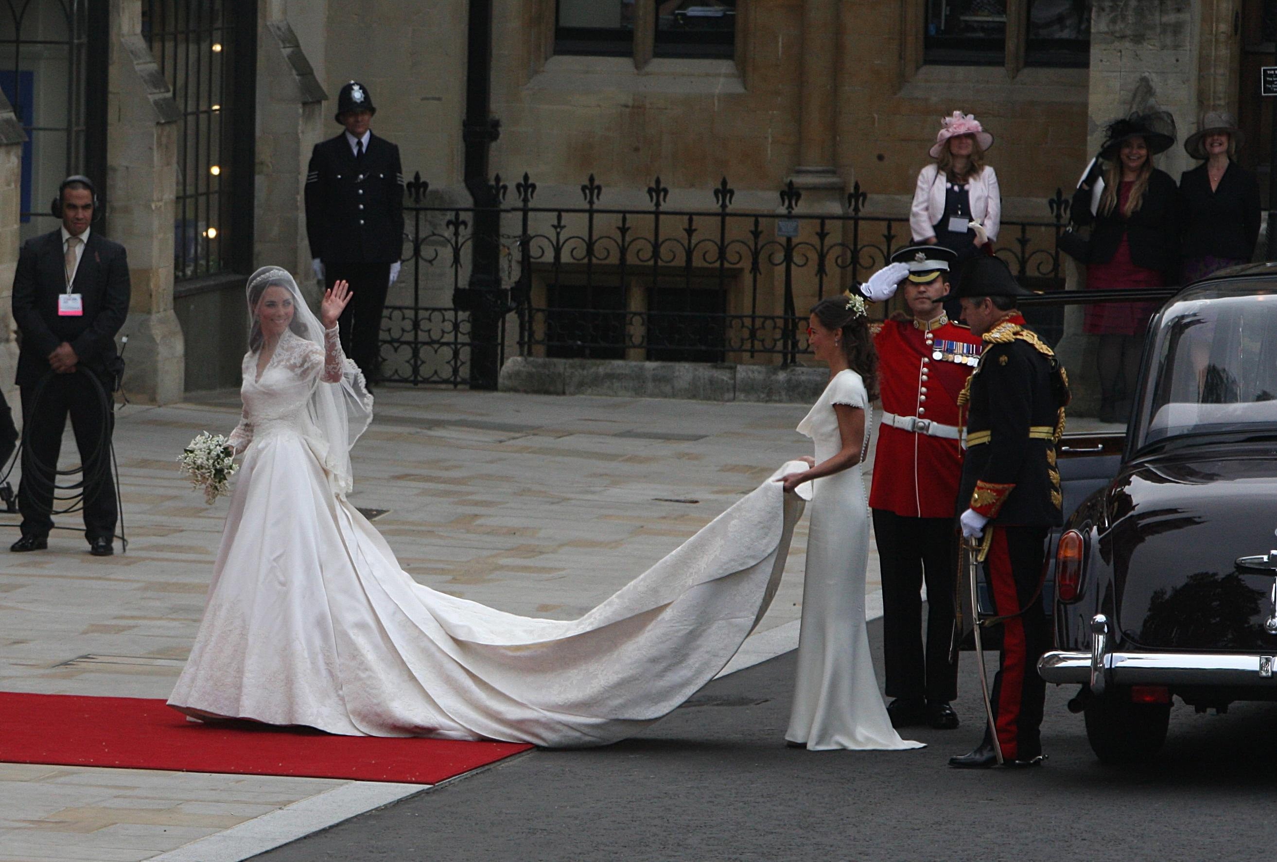 Kate Middleton waves as she arrives at Westminster Abbey where she is helped with her dress by her sister Pippa ahead of her wedding with Prince William