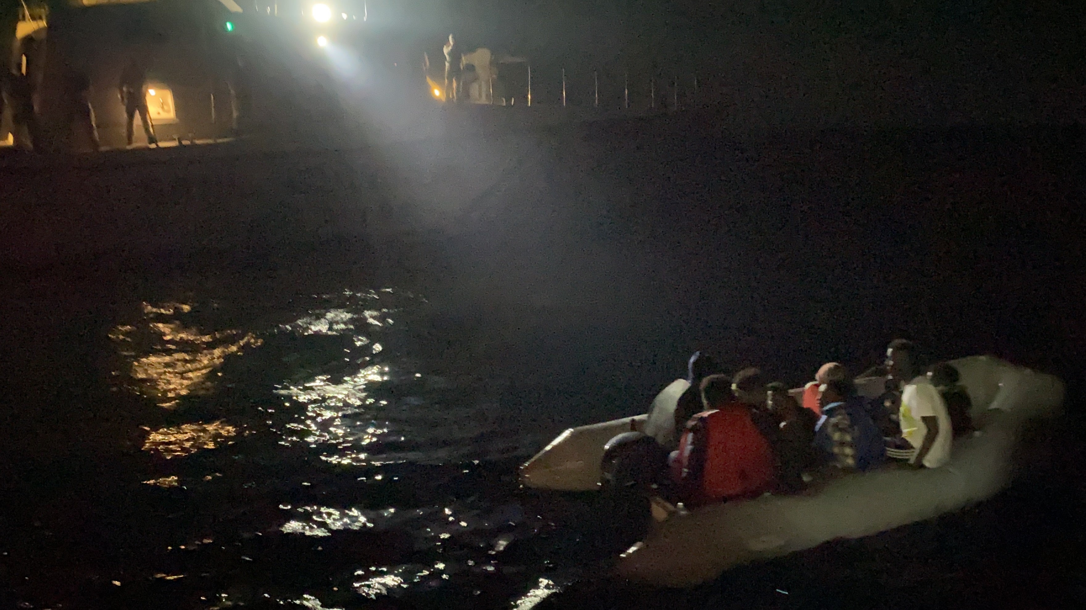 Coastguards attempt to rescue a group of migrants stranded in the Aegean Sea