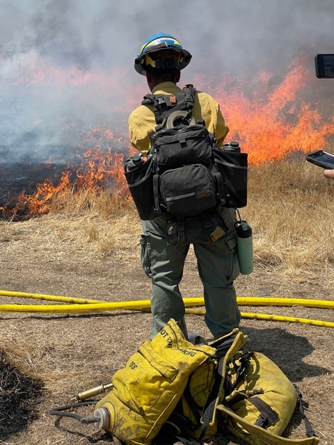 Inland Crew 5 firefighter Miracle Darnell monitors the fire line during a controlled burn