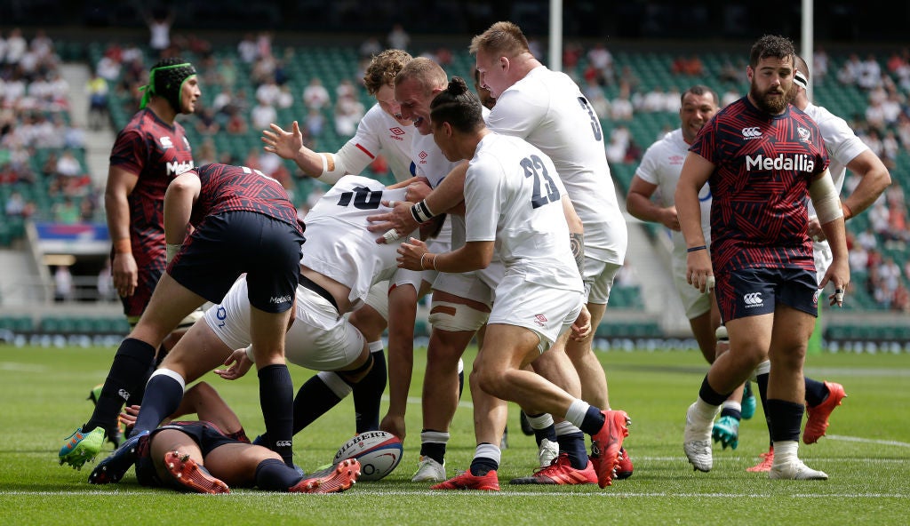 Jamie Blamire is mobbed by his England teammates after scoring a try on his international debut