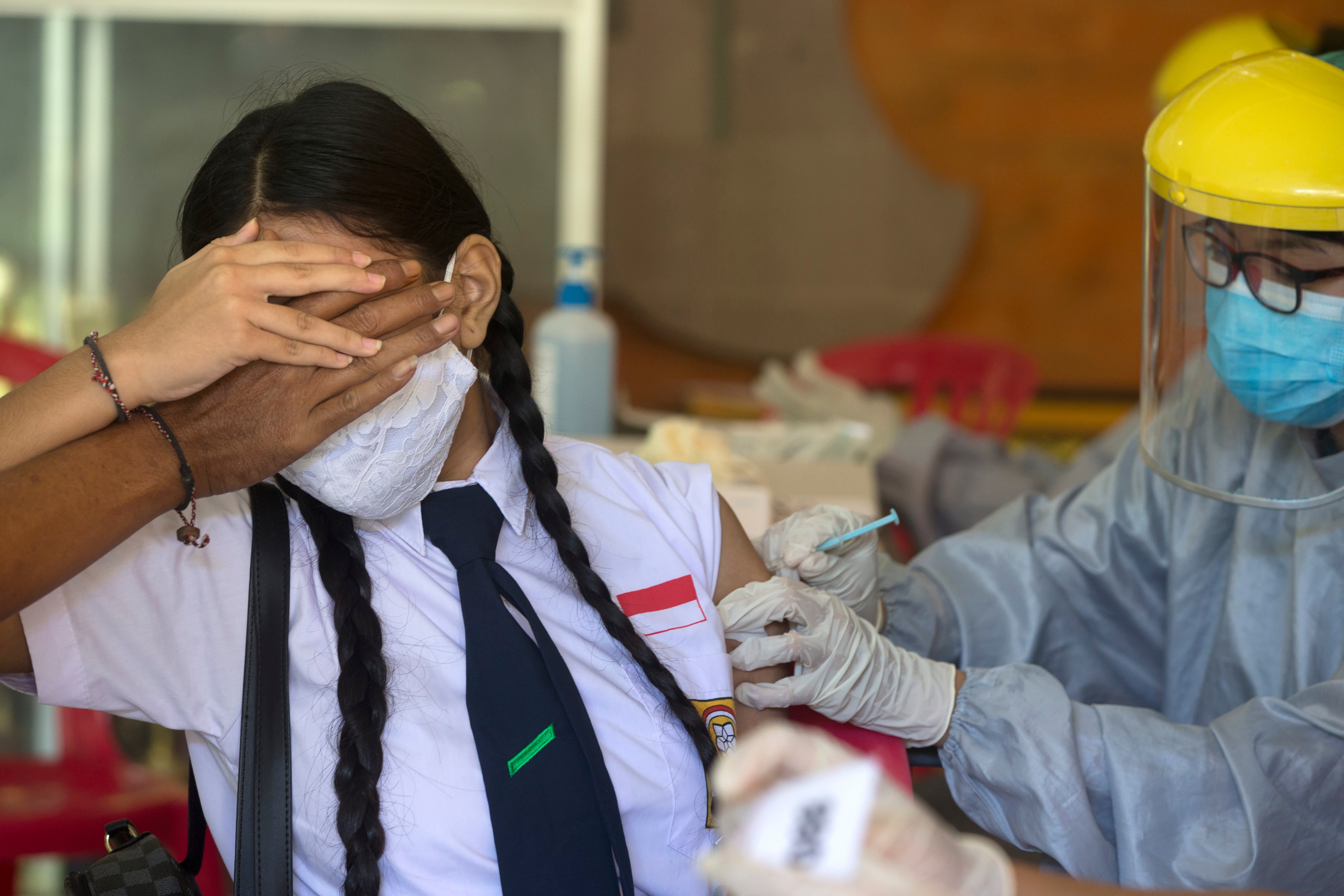 A teenager receives a shot of the Sinovac vaccine in Bali, Indonesia, on 5 July