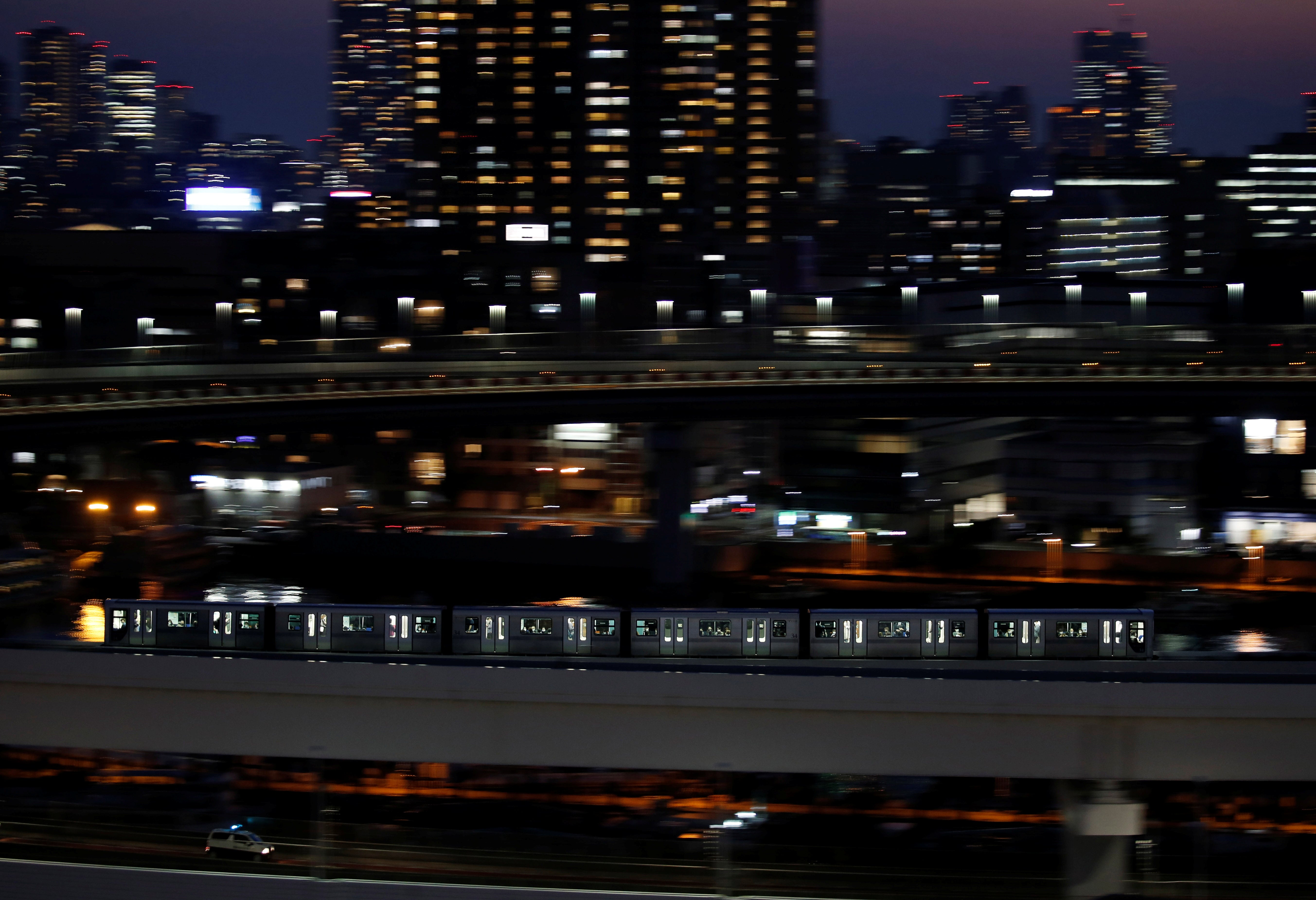 A Yurikamome line train, a driverless automatic train system, travels past buildings in Tokyo