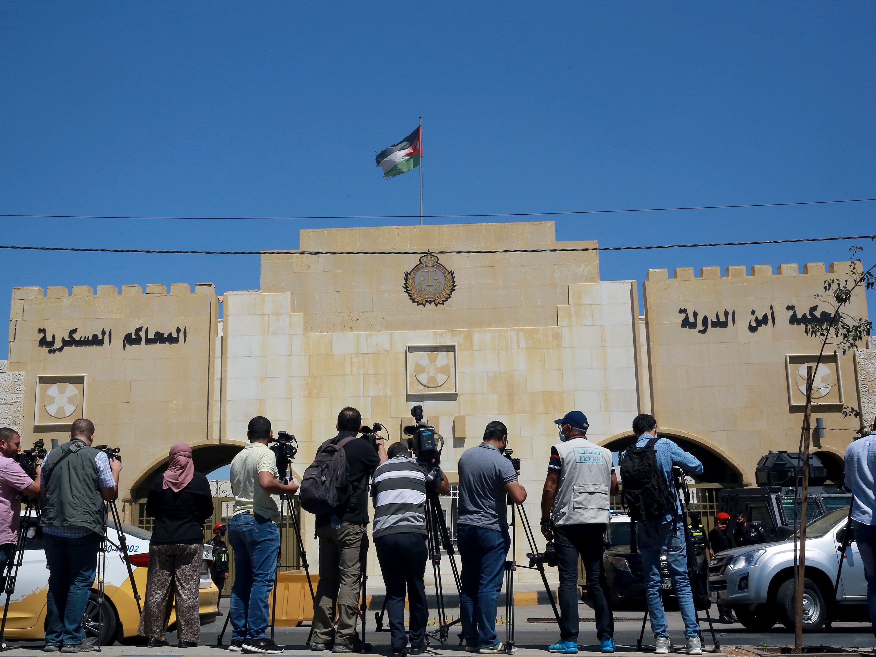 Reporters stand outside the state security court