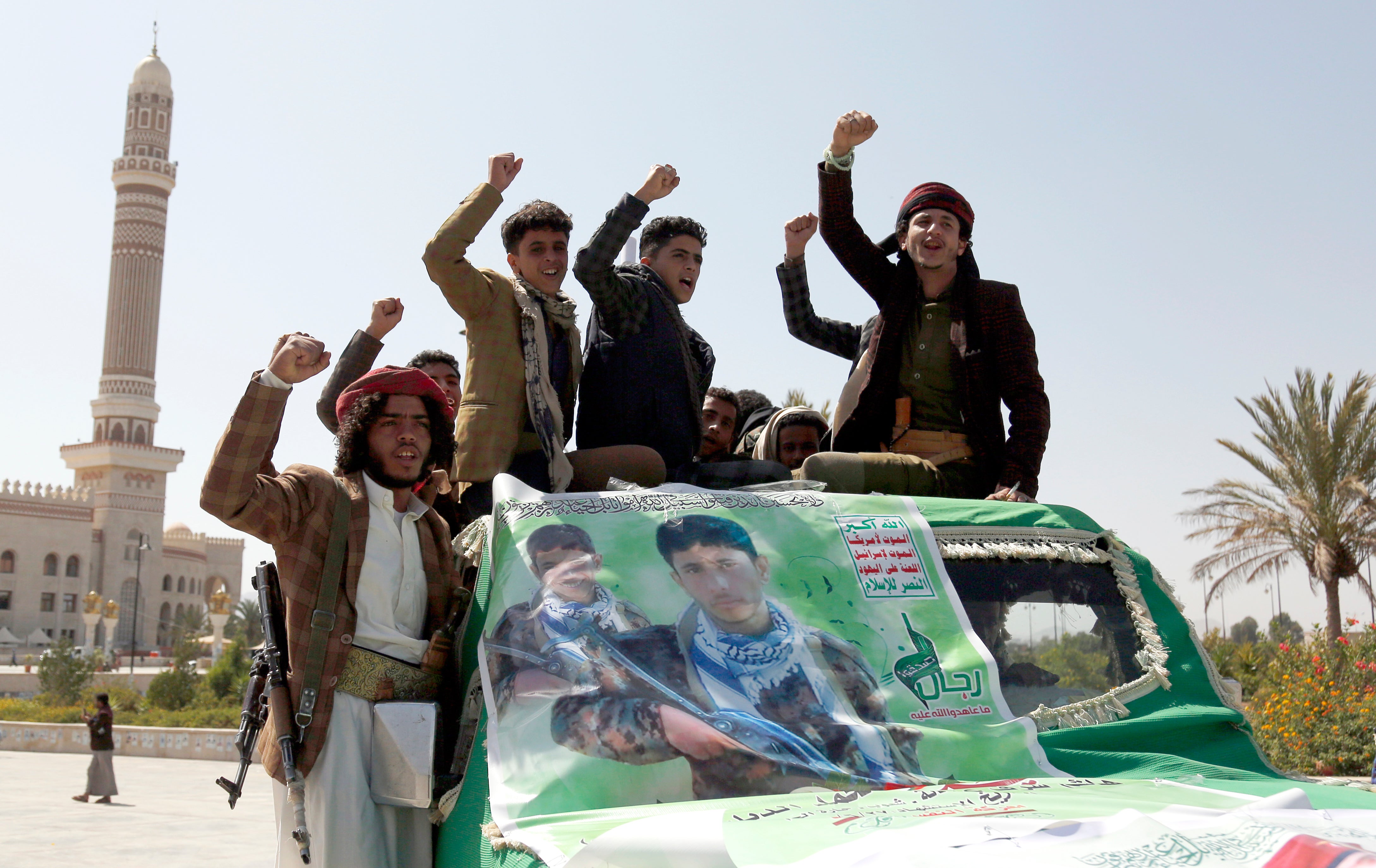 Houthi followers shout slogans as they ride a truck carrying the coffin of a fighter who was killed in the ongoing fighting between the Houthi movement and forces of the government over the control of Yemen's oil-rich region of Marib