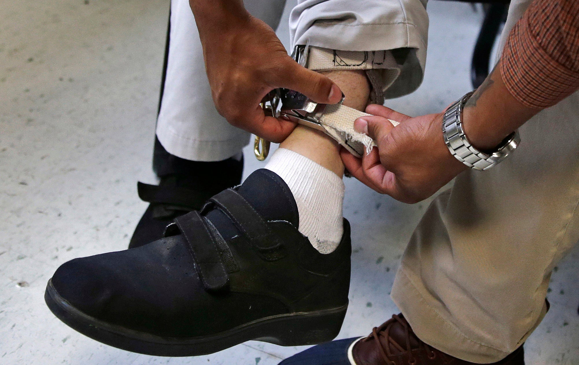 Staff check the ankle strap of an electrical shocking device on a student during an exercise programme at the Judge Rotenberg Educational Center in Canton